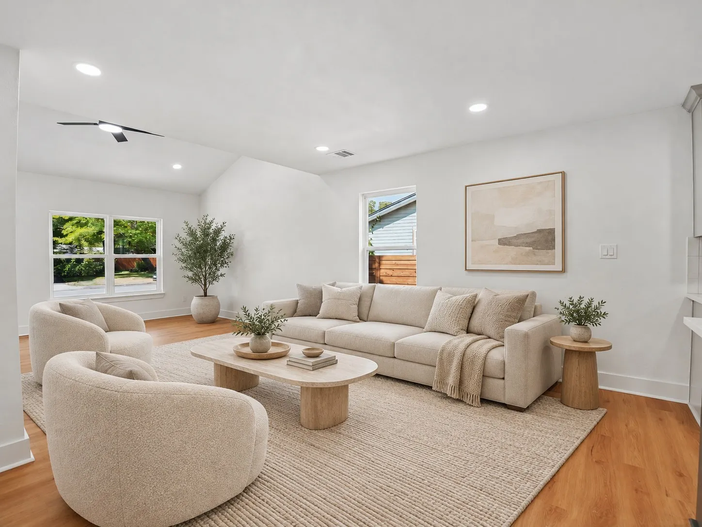 Vaulted ceilings featuring recessed lighting and a central ceiling fan, paired with wood-finish flooring and multiple windows