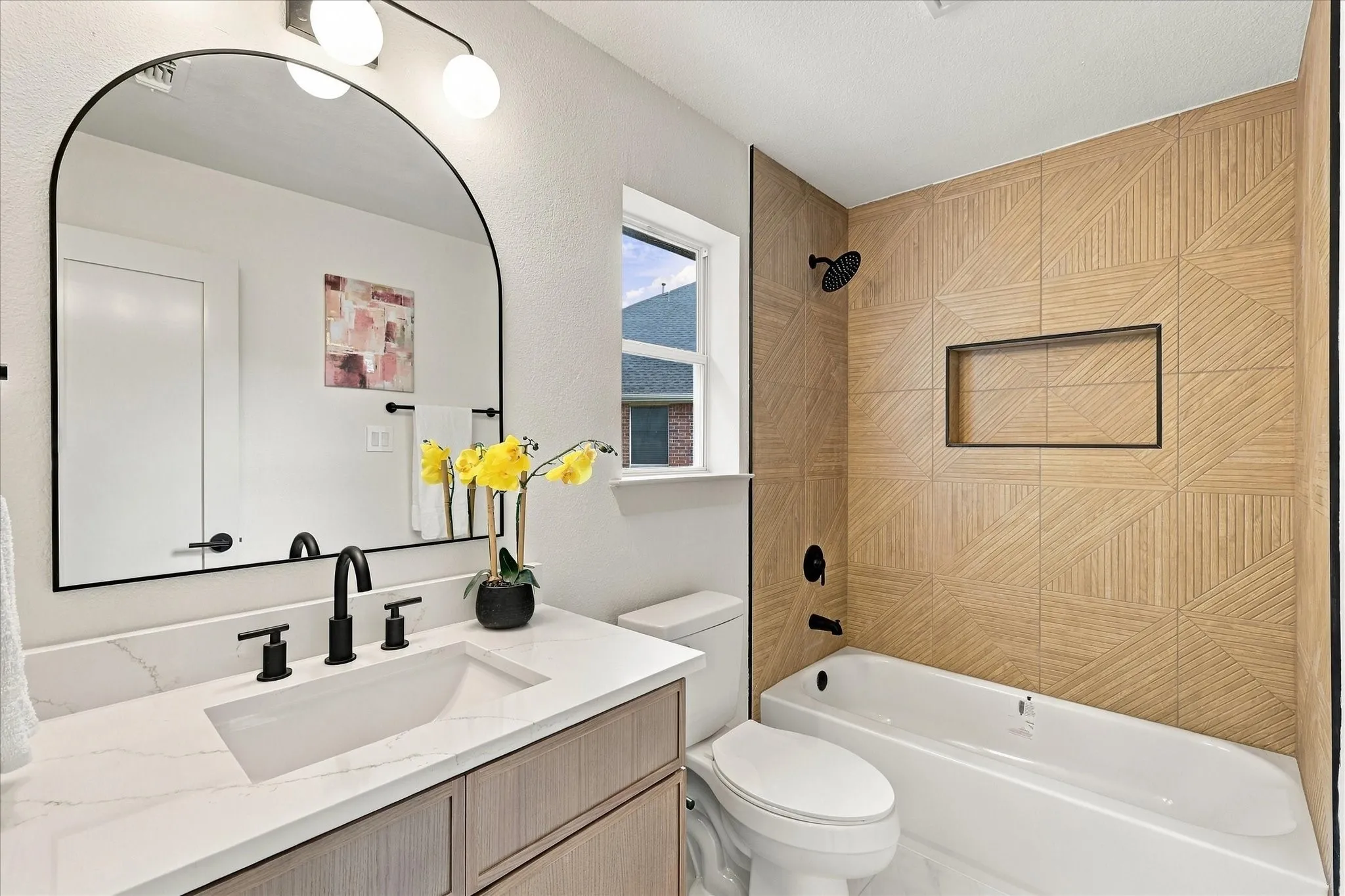 Bathroom featuring a vanity with white stone-finish countertop, undermount sink, and matte black faucet