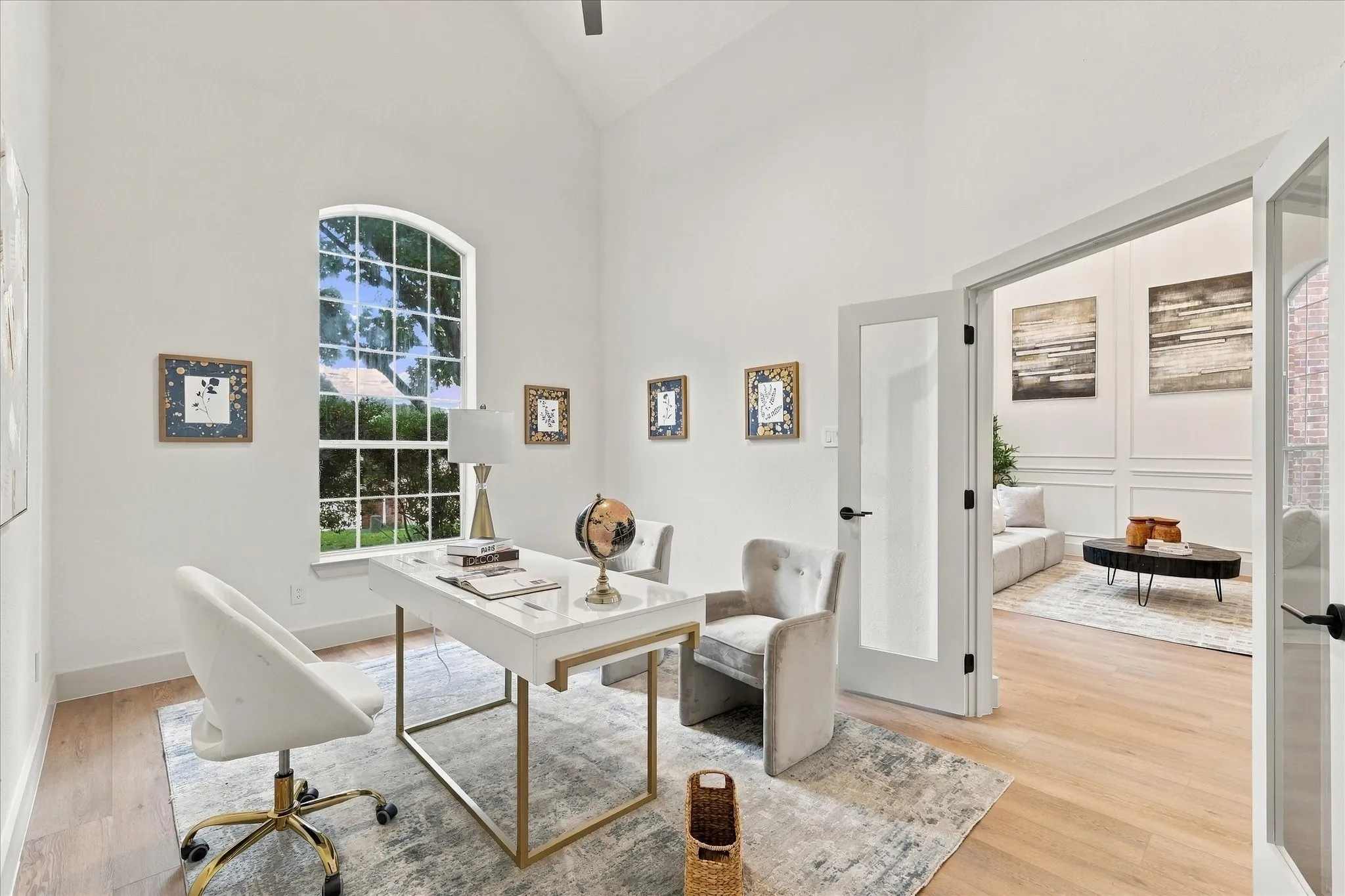 Vaulted ceilings, arched window, wood-finish flooring, and glass-paneled double doors