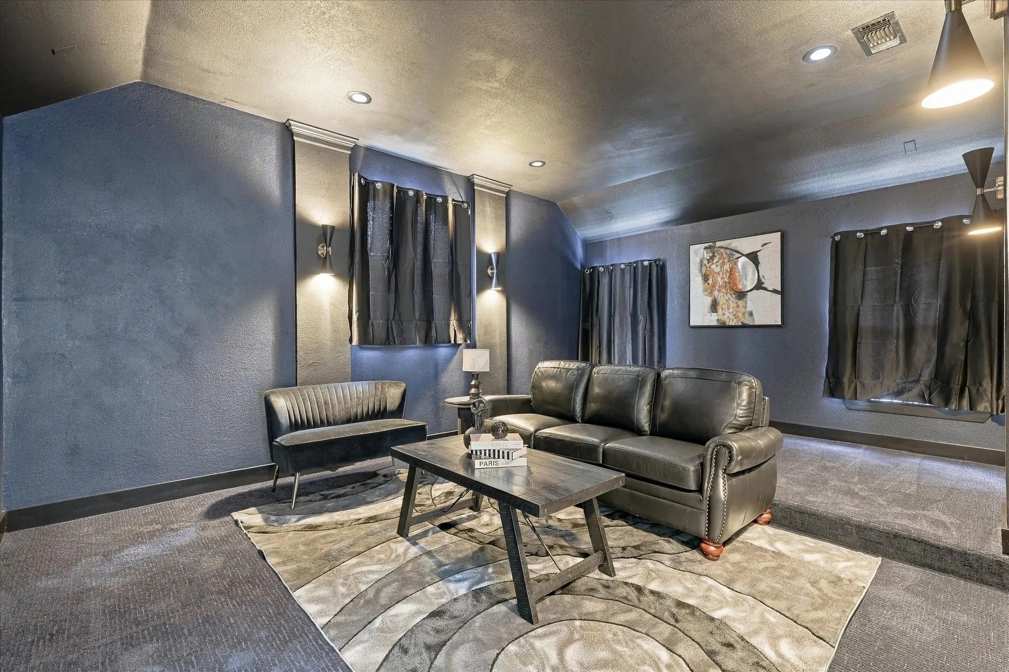 Room featuring vaulted ceilings, recessed lighting, wall-mounted sconces, and dual-level flooring
