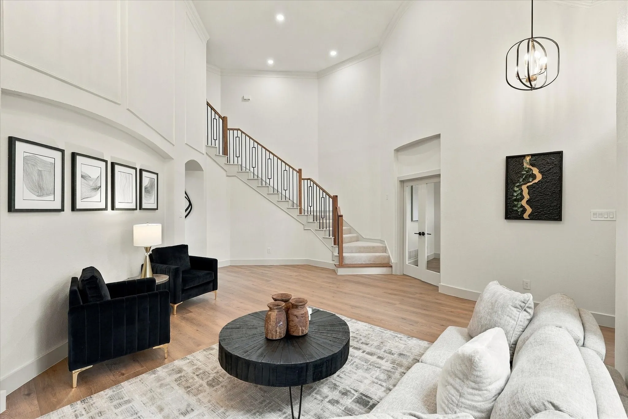 Double-height ceilings featuring recessed lighting, expansive entryway with wood-finish flooring, and a staircase with metal balusters and wood handrail