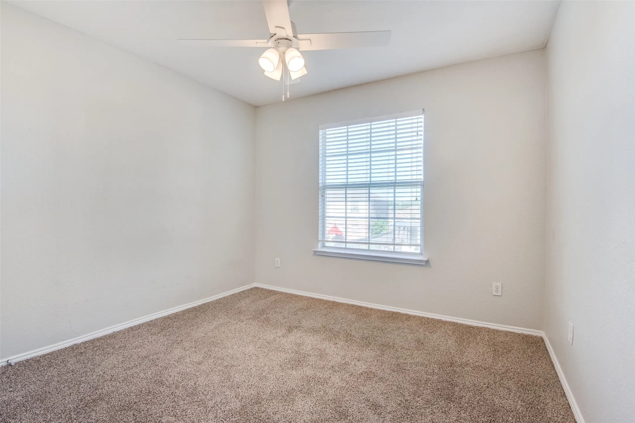 Carpeted empty room with ceiling fan