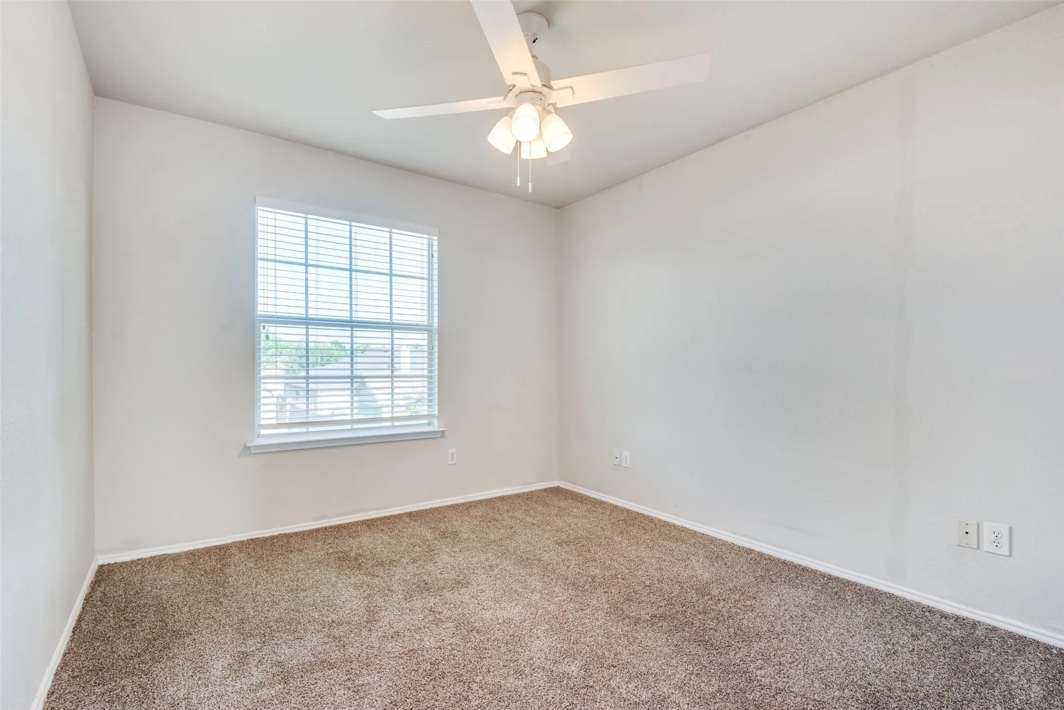 Empty room with carpet flooring and ceiling fan