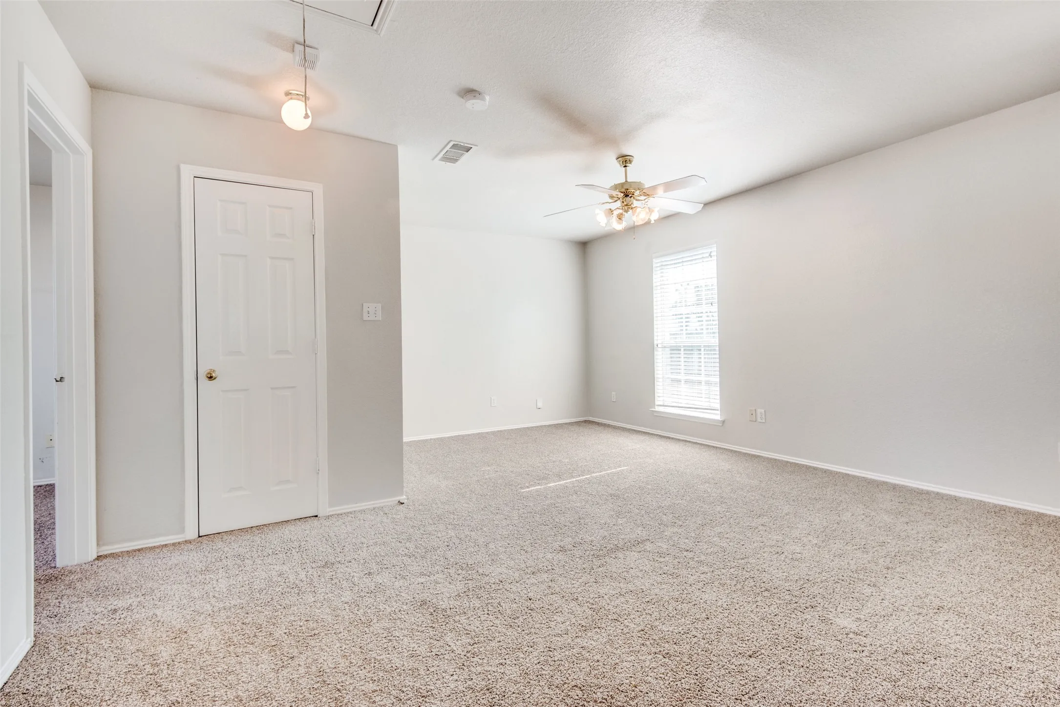Carpeted spare room with ceiling fan