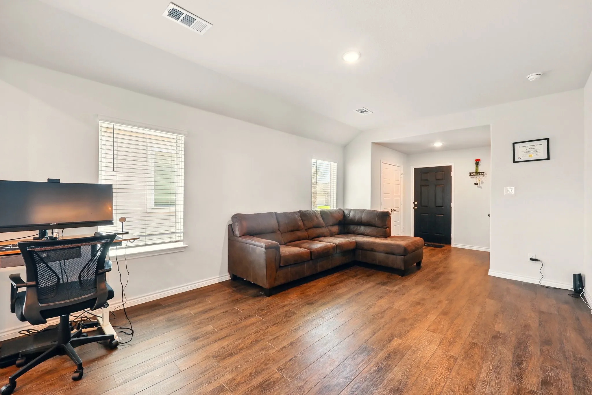 Wood-finish flooring throughout, recessed lighting, and a white interior paint palette
