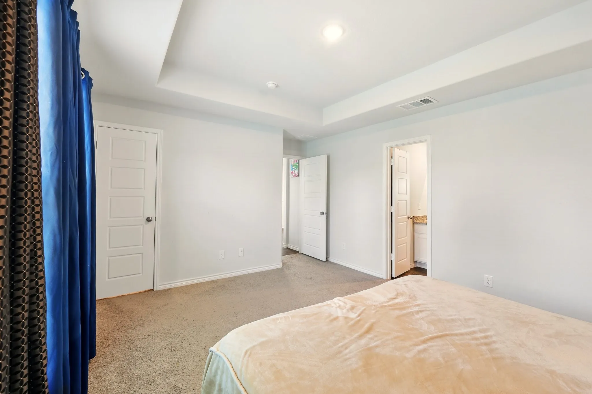 Neutral wall finishes, recessed ceiling lighting, and carpet flooring