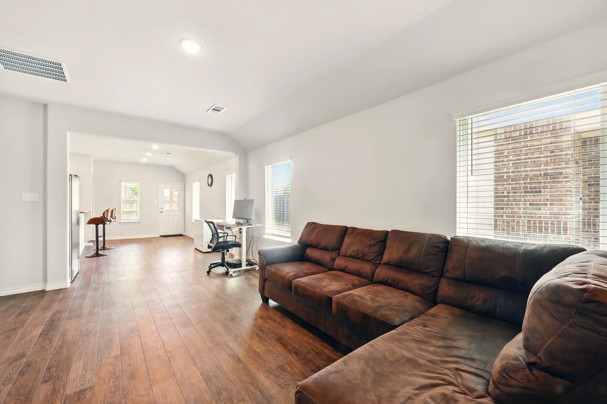 Wood-finish flooring throughout, vaulted ceilings, and multiple windows providing natural light