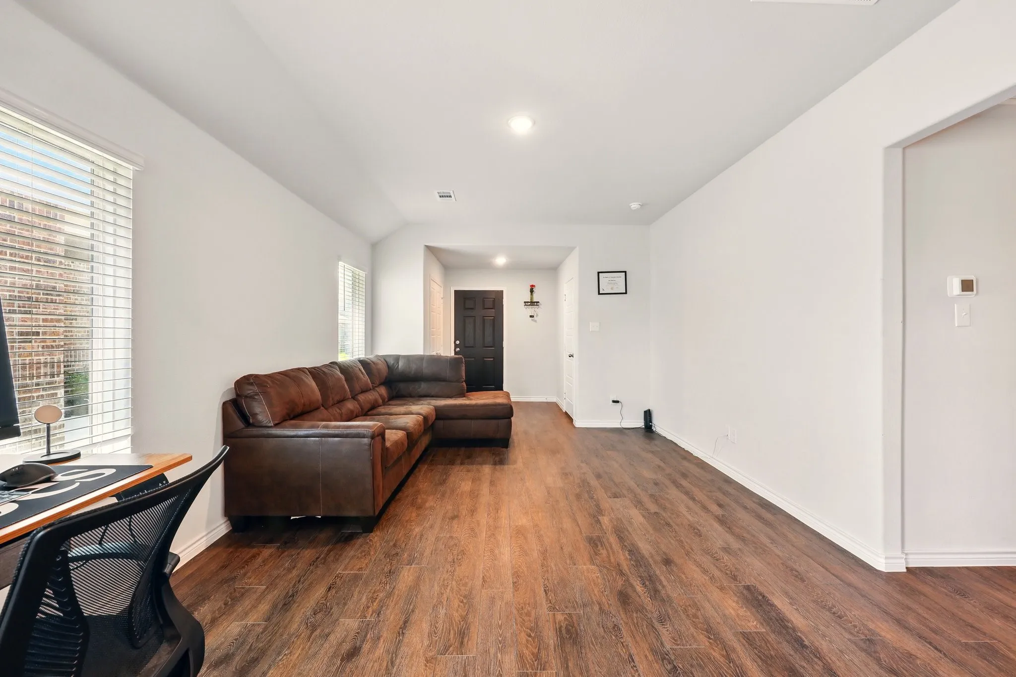 Wood-finish flooring throughout, white walls, and recessed lighting
