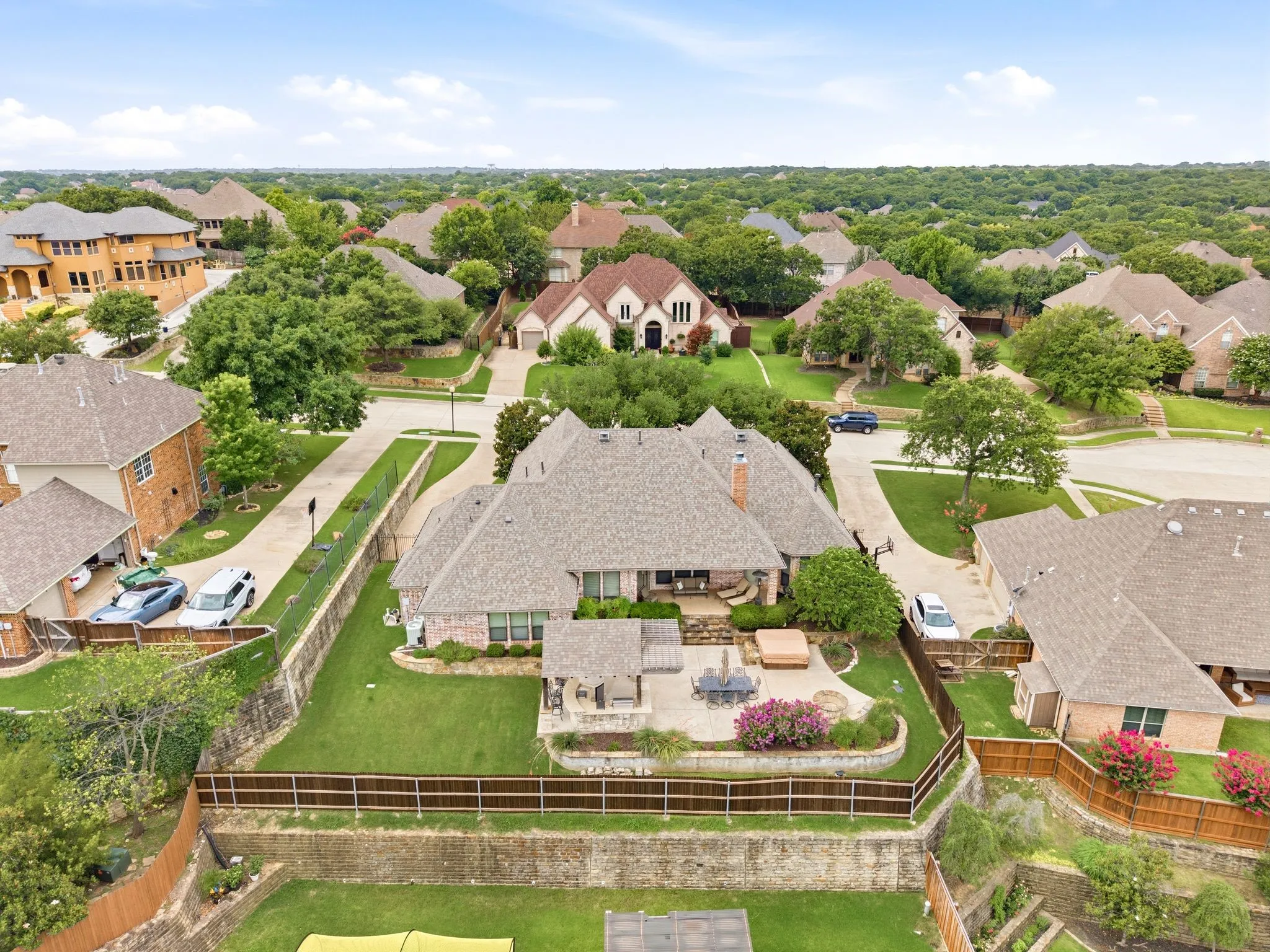 Expansive property featuring a stone patio, built-in hot tub, and an outdoor kitchen area