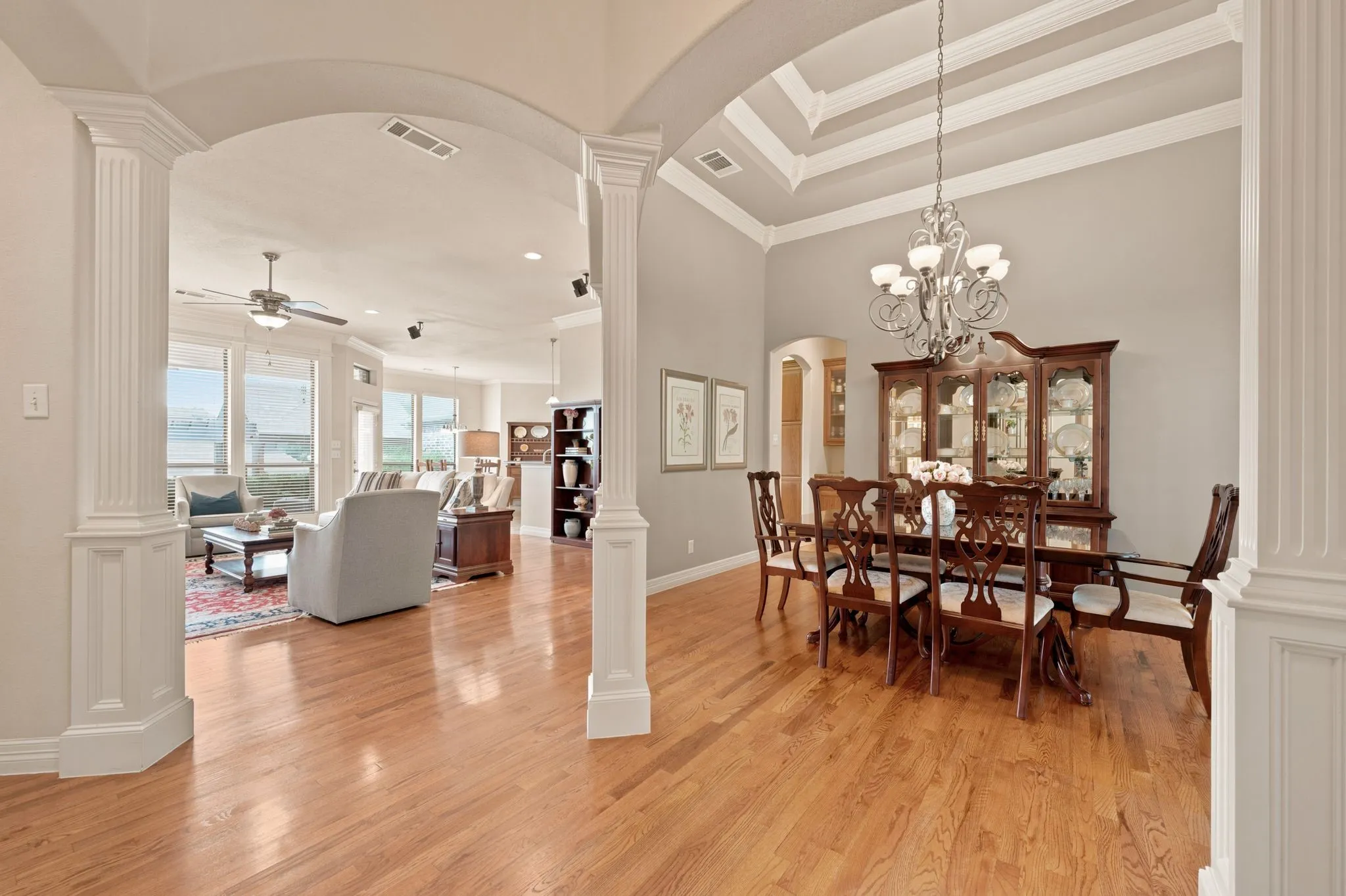 Dining area featuring wood-finish flooring, a coffered ceiling, and a decorative chandelier