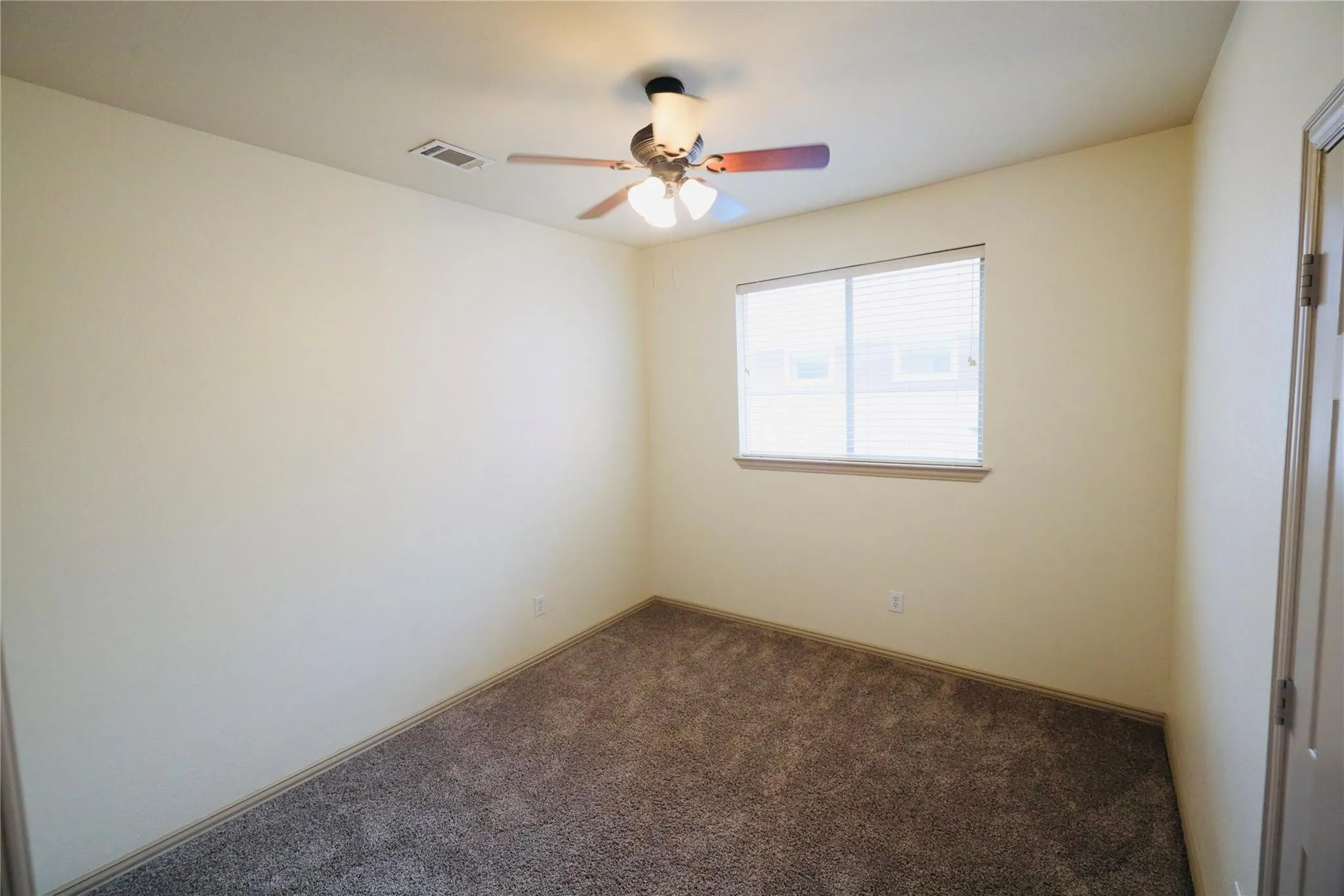 Neutral-toned walls complement the textured carpet flooring