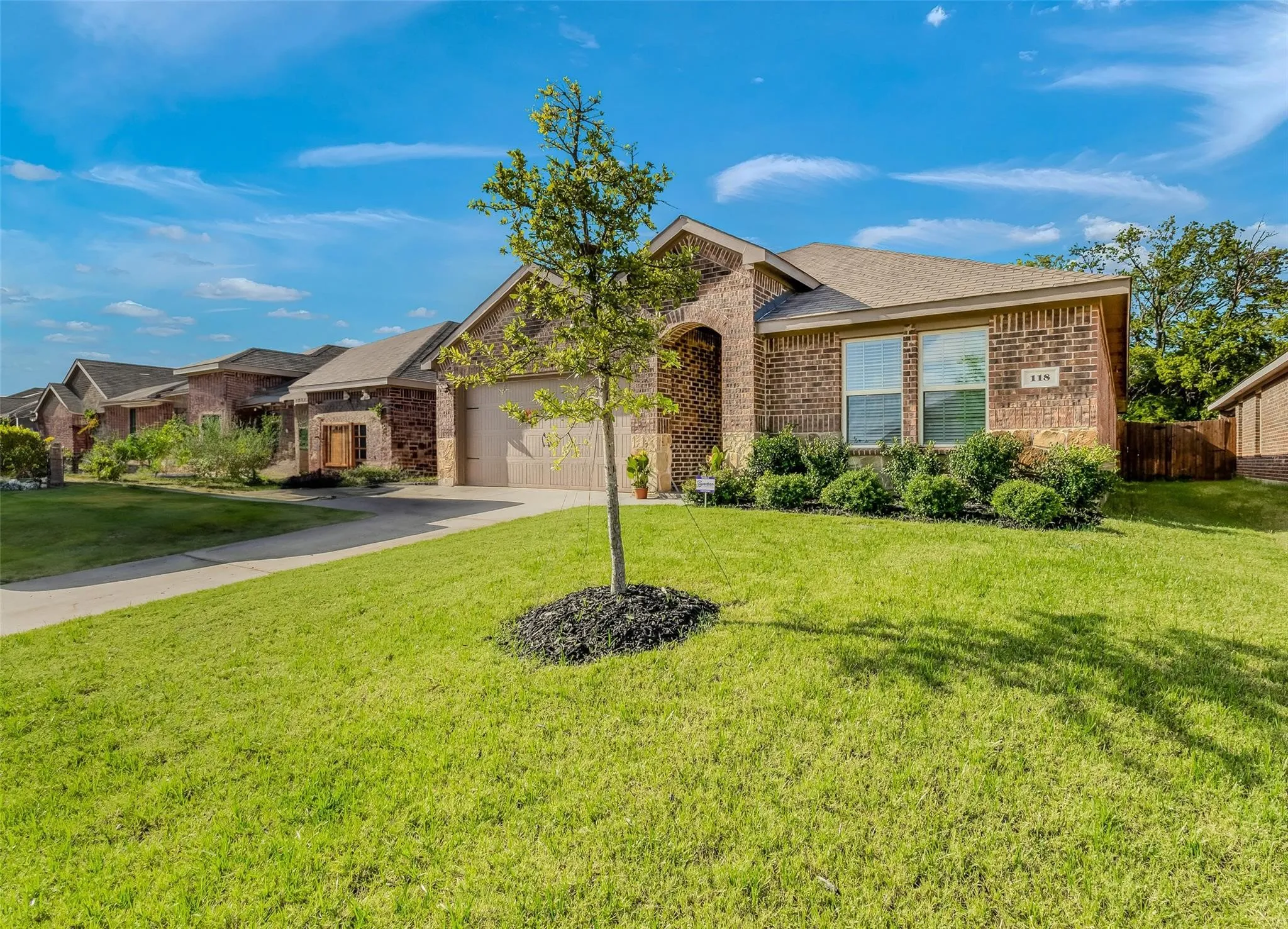 Ranch-style house featuring a garage and a front lawn