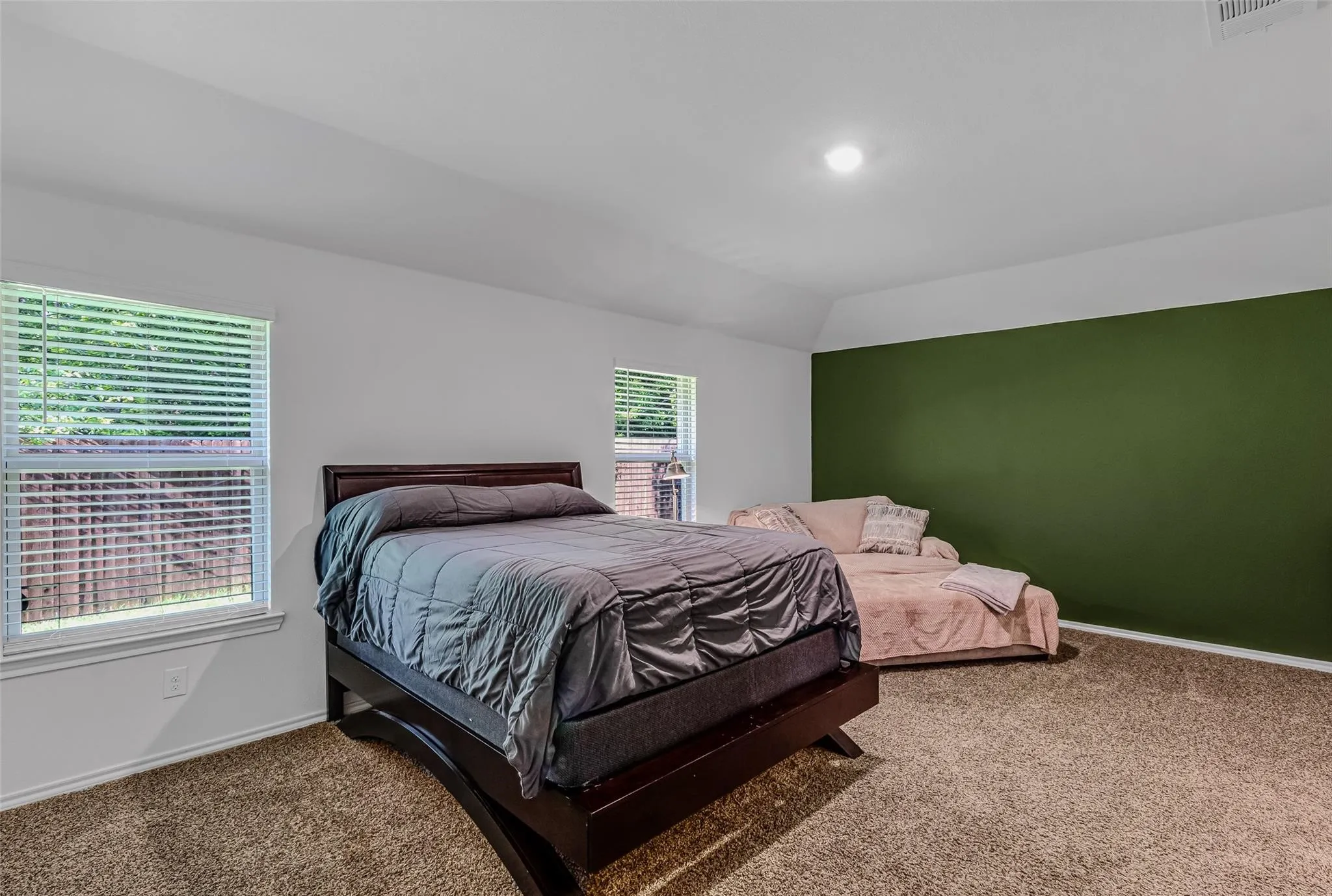 Bedroom with carpet flooring and vaulted ceiling