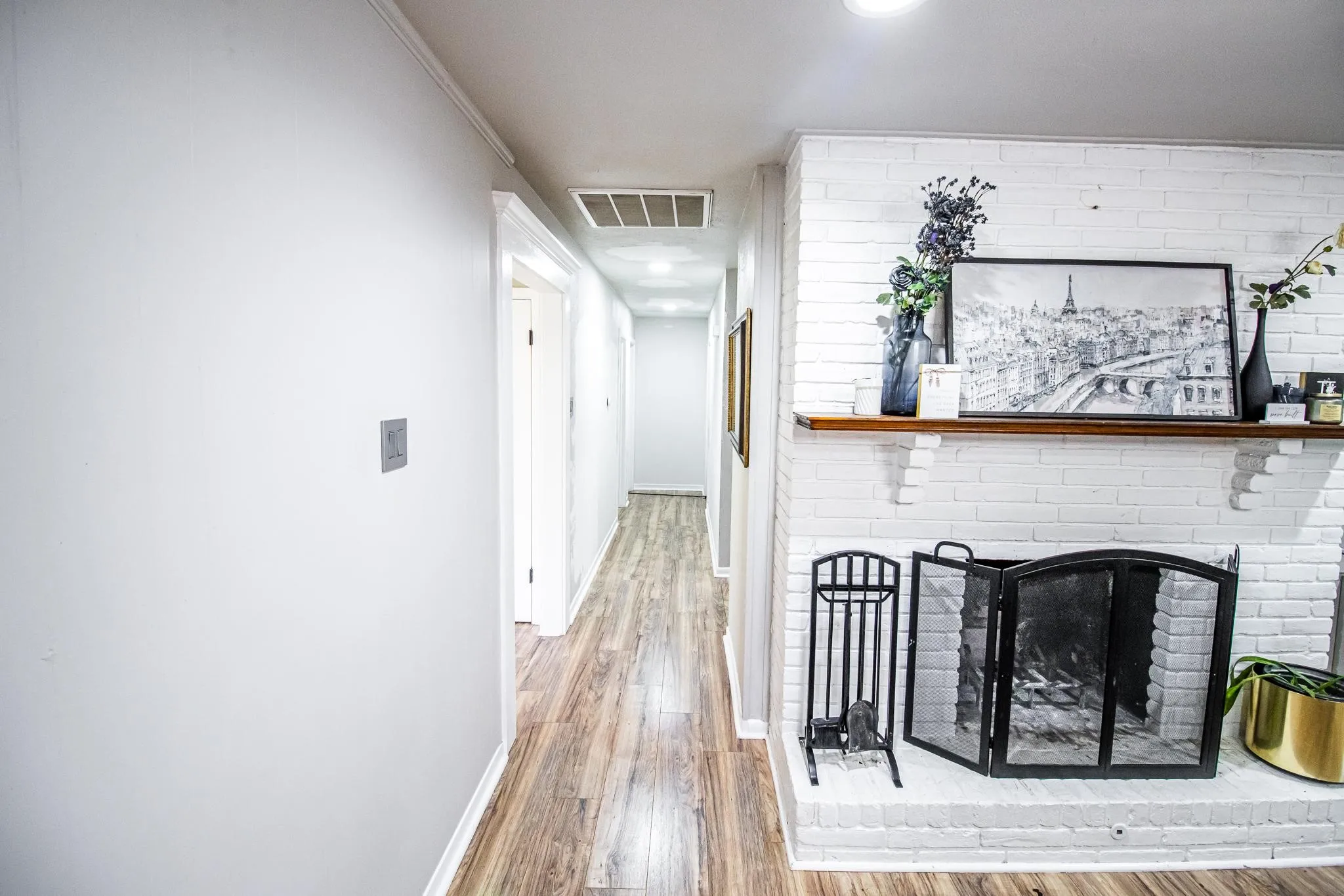 White painted brick fireplace featuring a wood mantel and recessed lighting