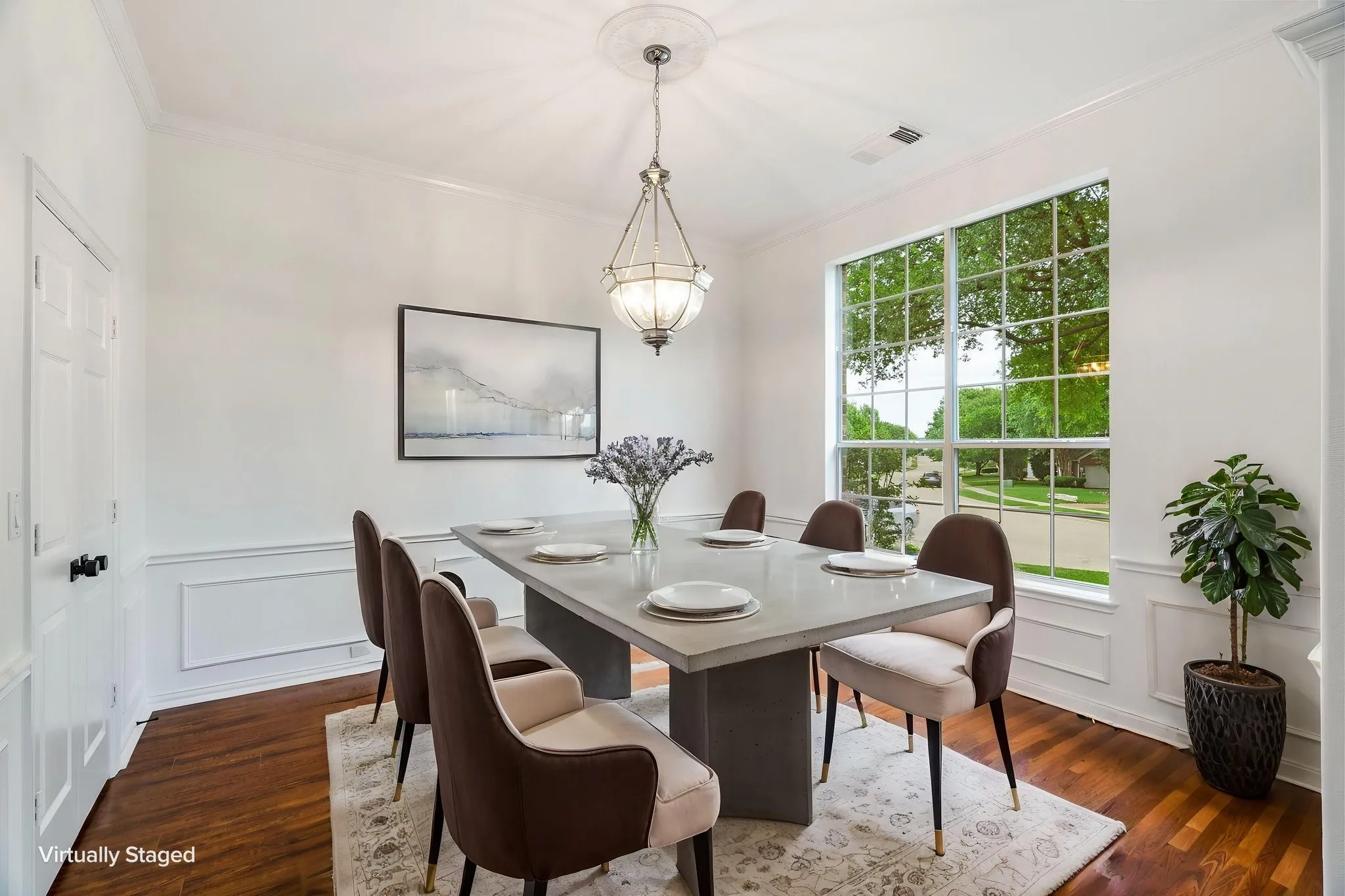 Hardwood-finish flooring, crown molding, wainscoting, and a large grid-pattern window