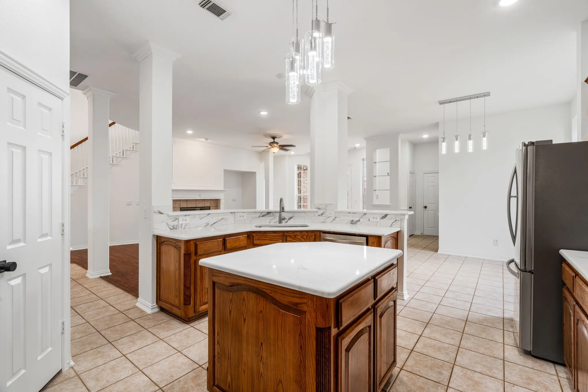 Kitchen featuring a center island, wood cabinetry, stone countertops, and tile flooring