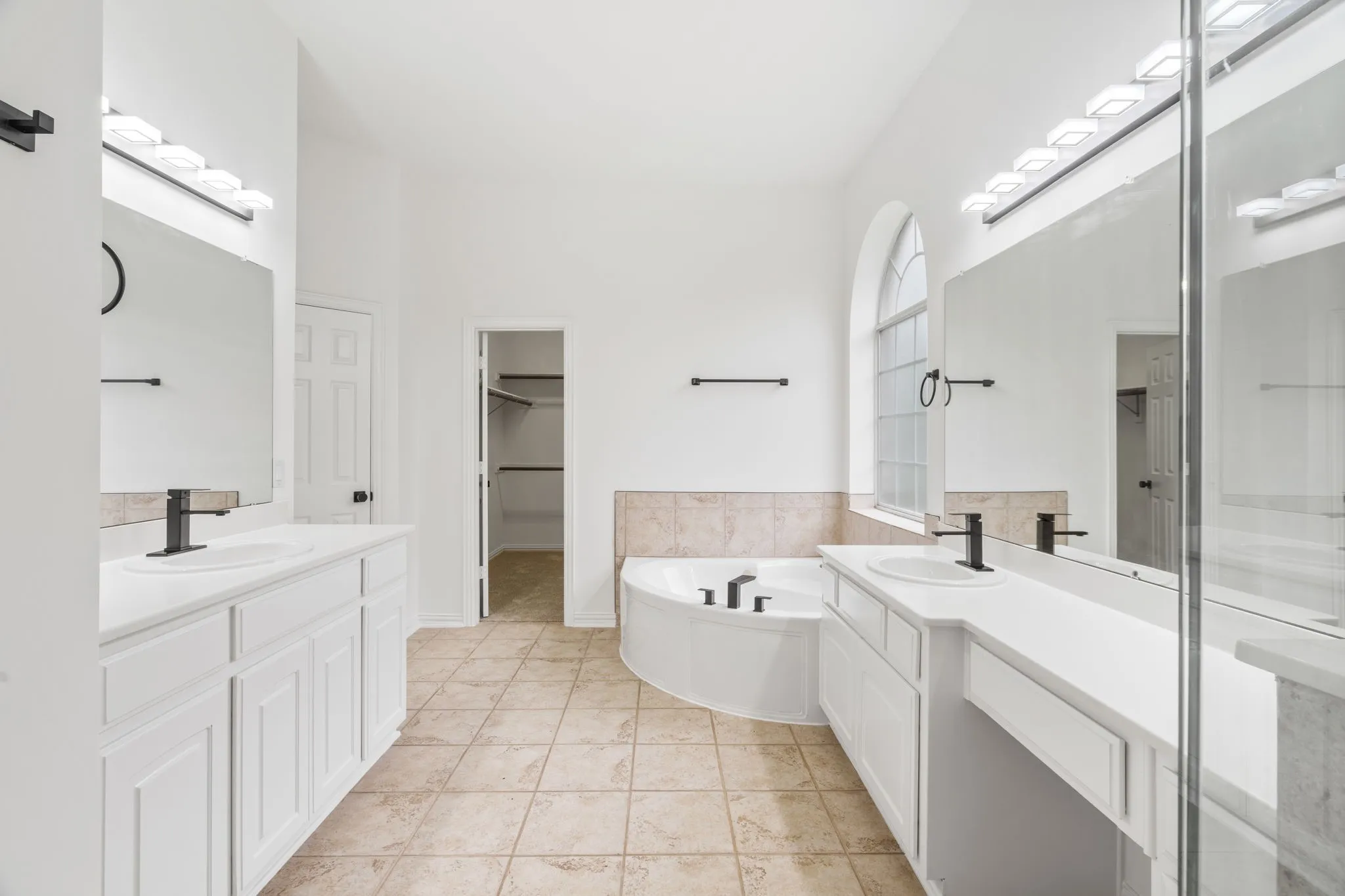 Dual vanities with white cabinetry and integrated sinks