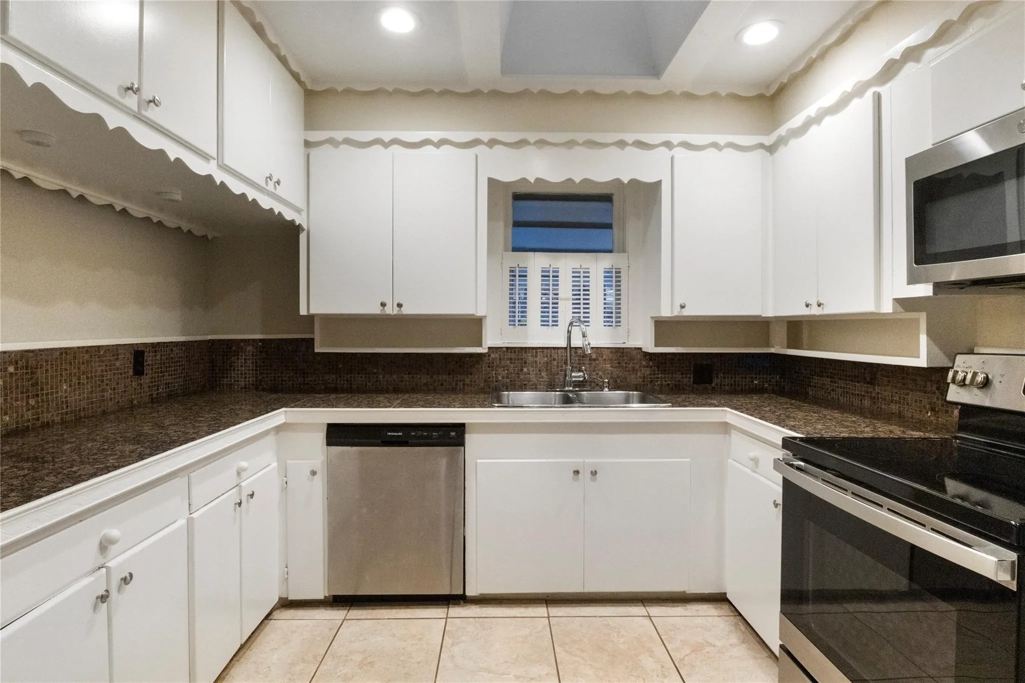 Kitchen featuring white cabinetry, stone-finish countertops, mosaic tile backsplash, recessed lighting, and stainless steel appliances