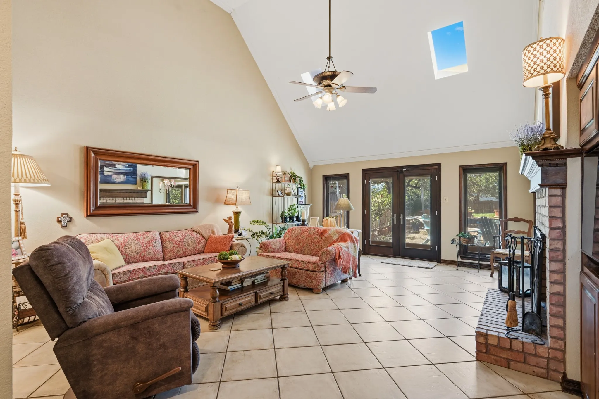 Spacious living room featuring soaring vaulted ceilings, a skylight, and abundant natural light.