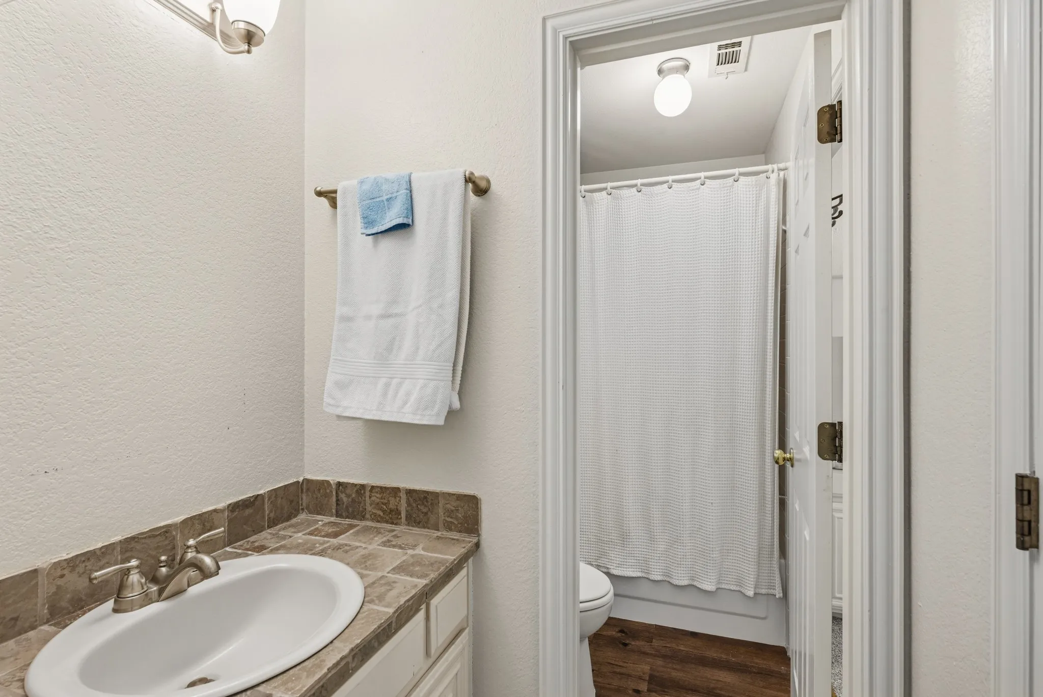 Upstairs bathroom has built in storage and a shower, tub combo.