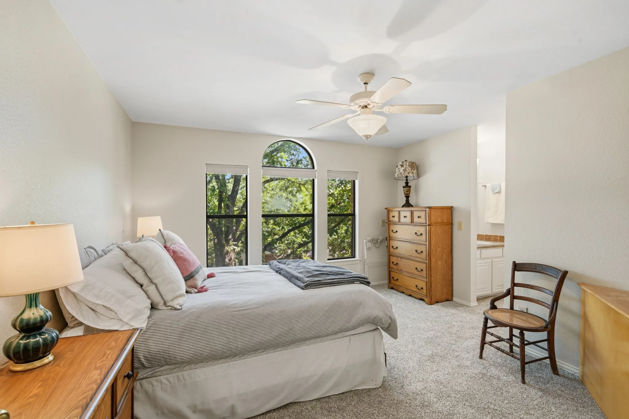 Secondary bedroom upstairs features a large window providing the room with an abundance of natural light. Also features an attached bathroom.