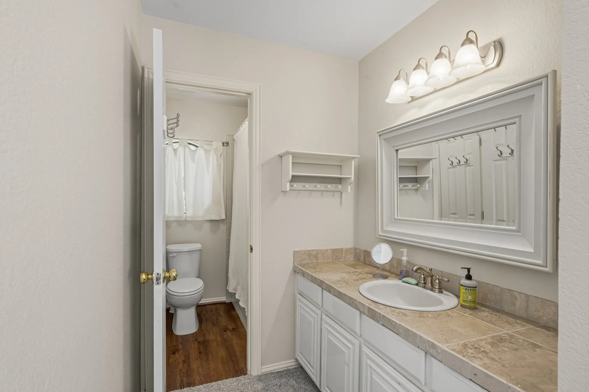 This upstairs bathroom is a jack and jill bathroom with each bedroom having their own vanity areas.