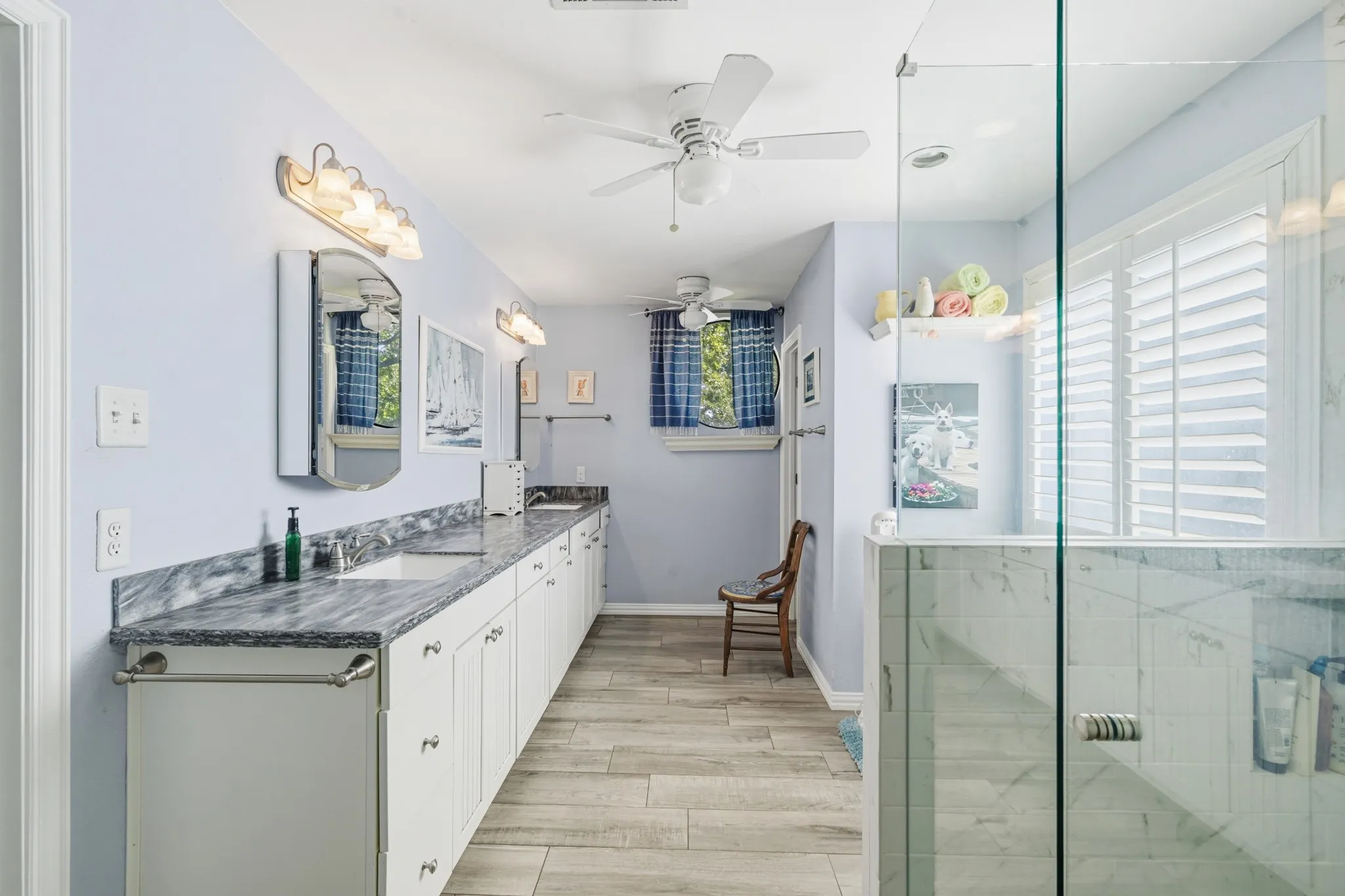 Spacious primary bathroom featuring an extended white vanity with ample cabinet storage and double sinks.