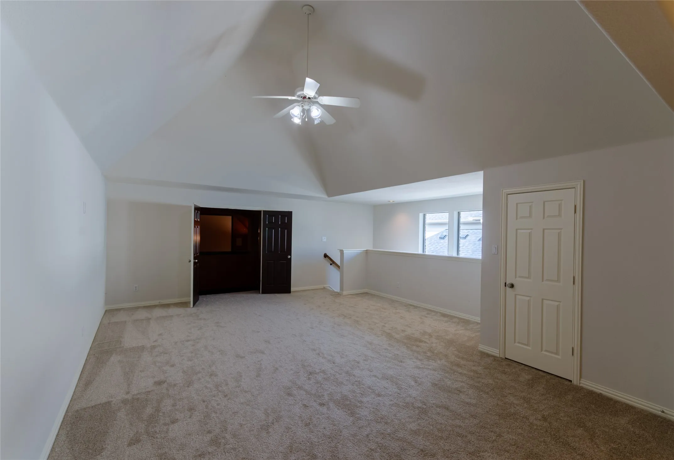 Game room Vaulted ceilings featuring a central overhead fan, neutral carpeting, and panel-style interior doors