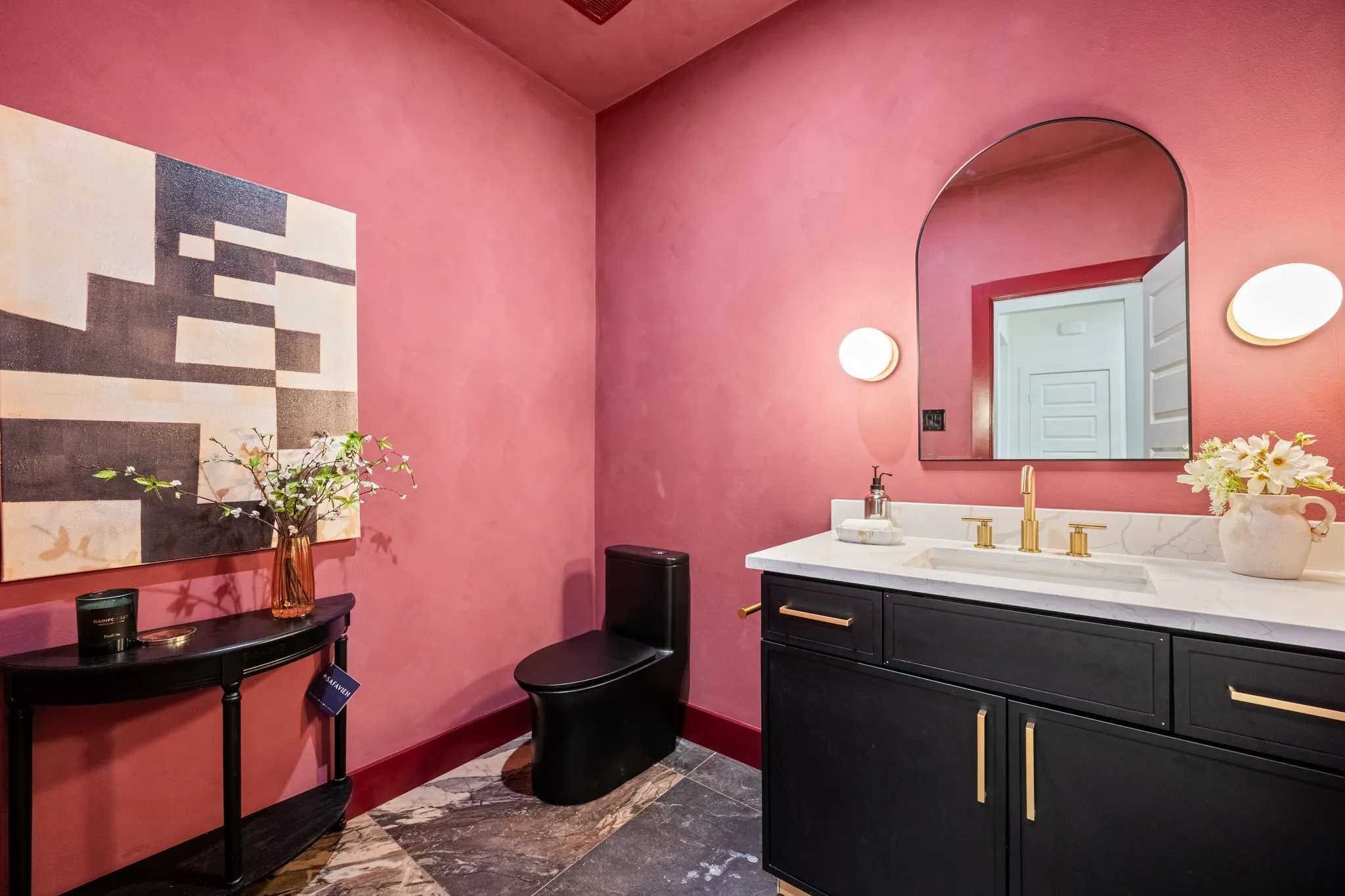 Burgundy lime wash walls with sconce lit vanity.