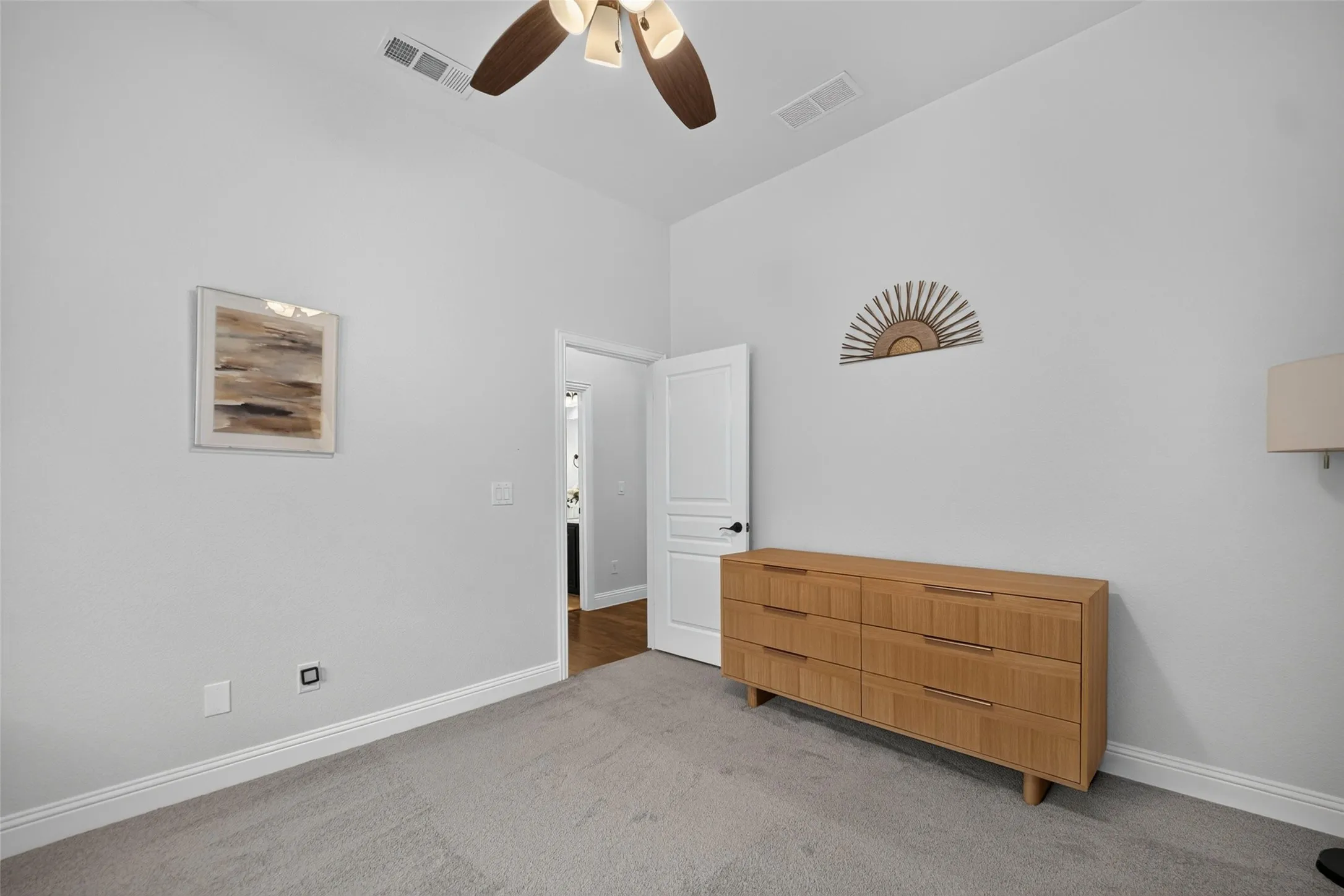 High ceiling featuring a multi-blade ceiling fan with integrated lighting and neutral carpeting