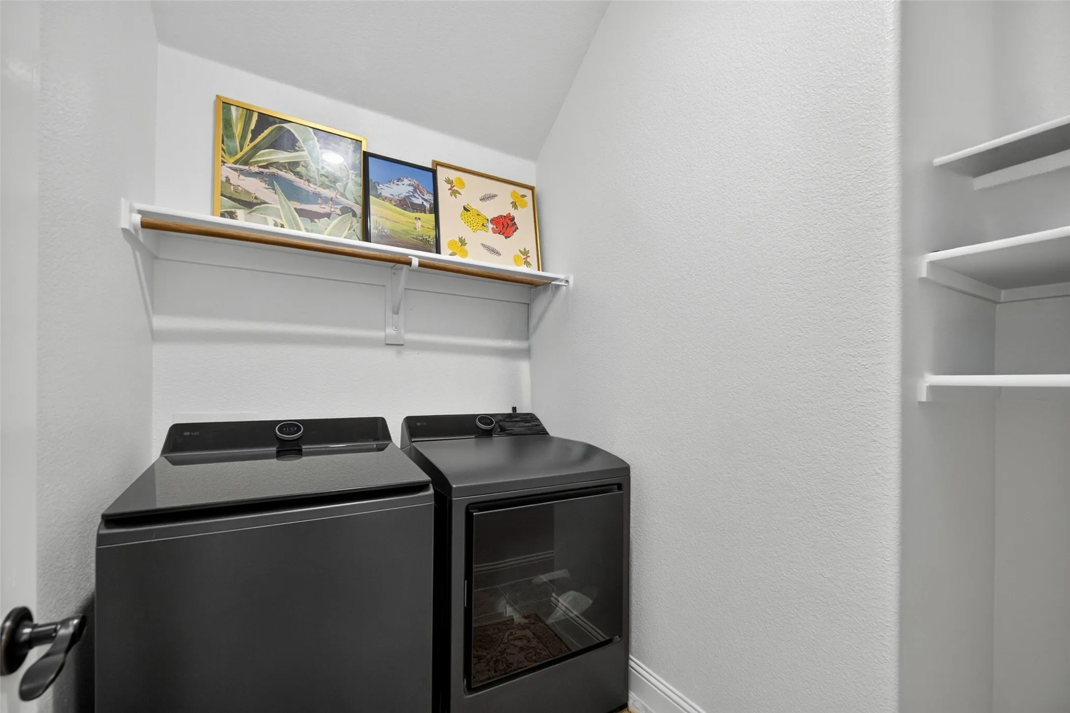 Laundry area featuring white built-in shelving and integrated hanging rods