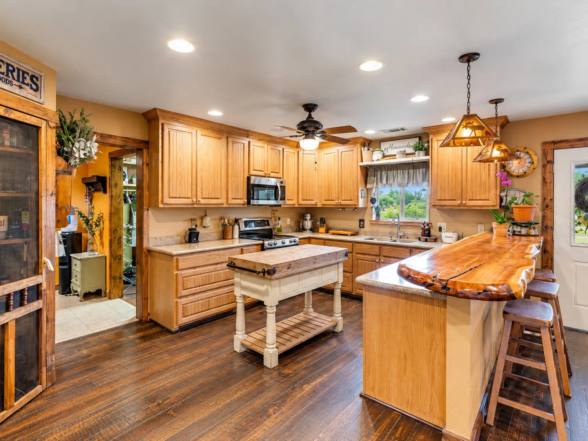 Kitchen featuring wood-finish flooring, recessed lighting, wood cabinetry, stainless steel appliances, and a live-edge wood breakfast bar