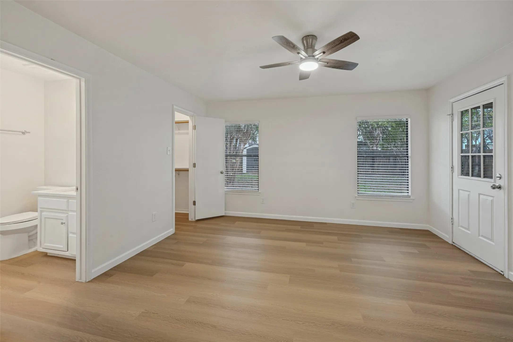 Utility room featuring white shaker-style wall-mounted cabinetry, wood-finish flooring, and dedicated washer and dryer hookups