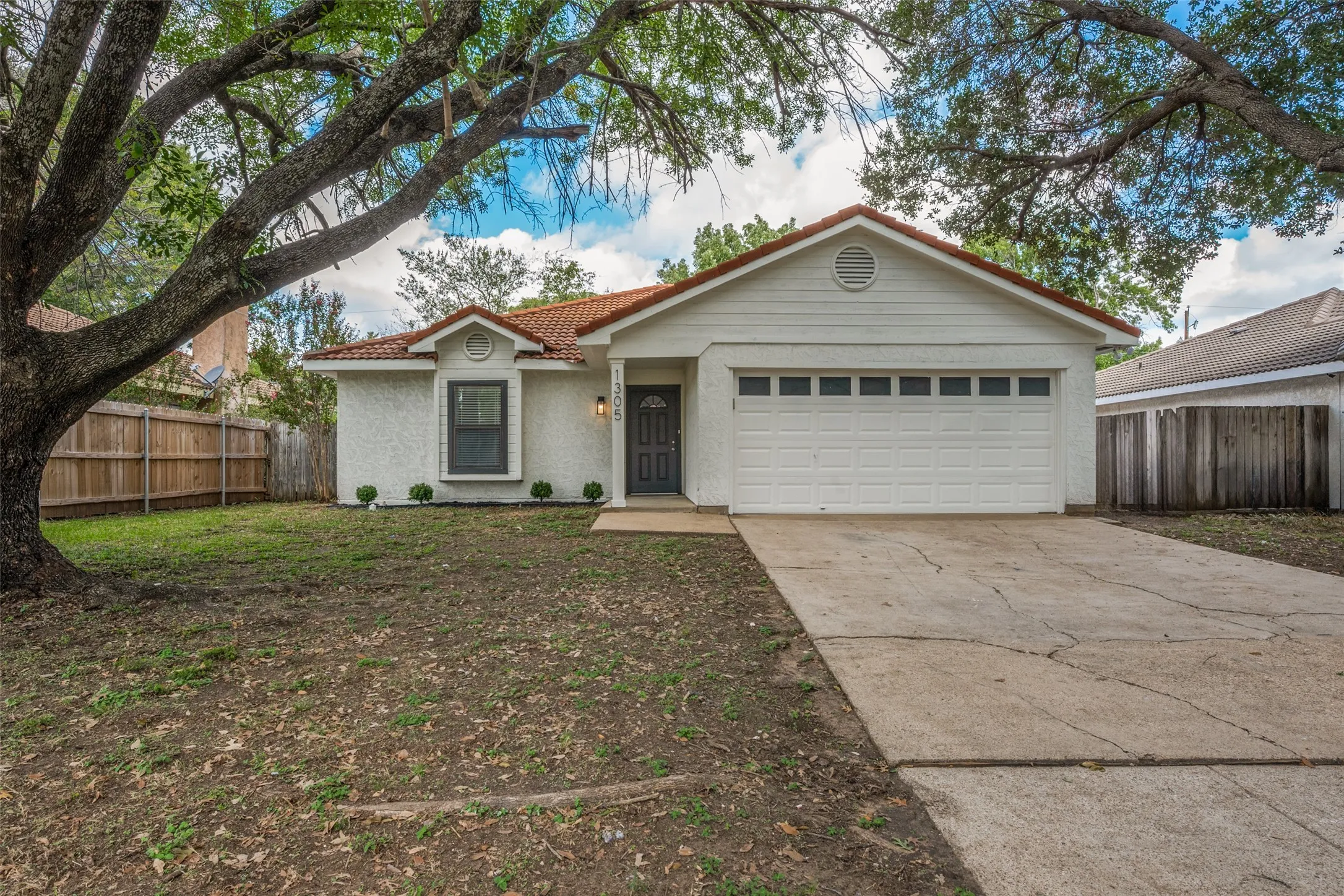 Single-story residence featuring a textured exterior finish, a multi-paneled garage door, a front-facing window with accent trim, and a concrete driveway