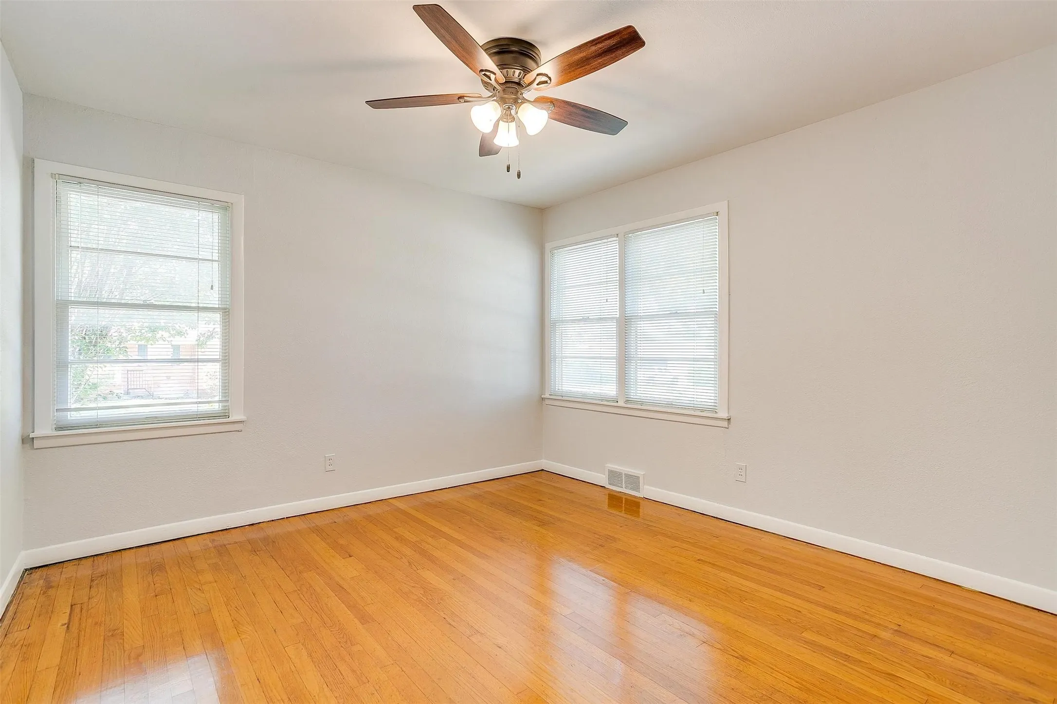 Spare room featuring light hardwood / wood-style floors, plenty of natural light, and ceiling fan