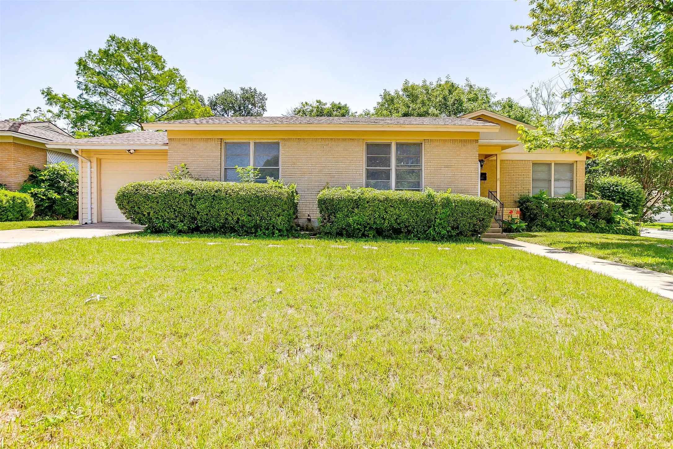 Single story home featuring a garage and a front lawn