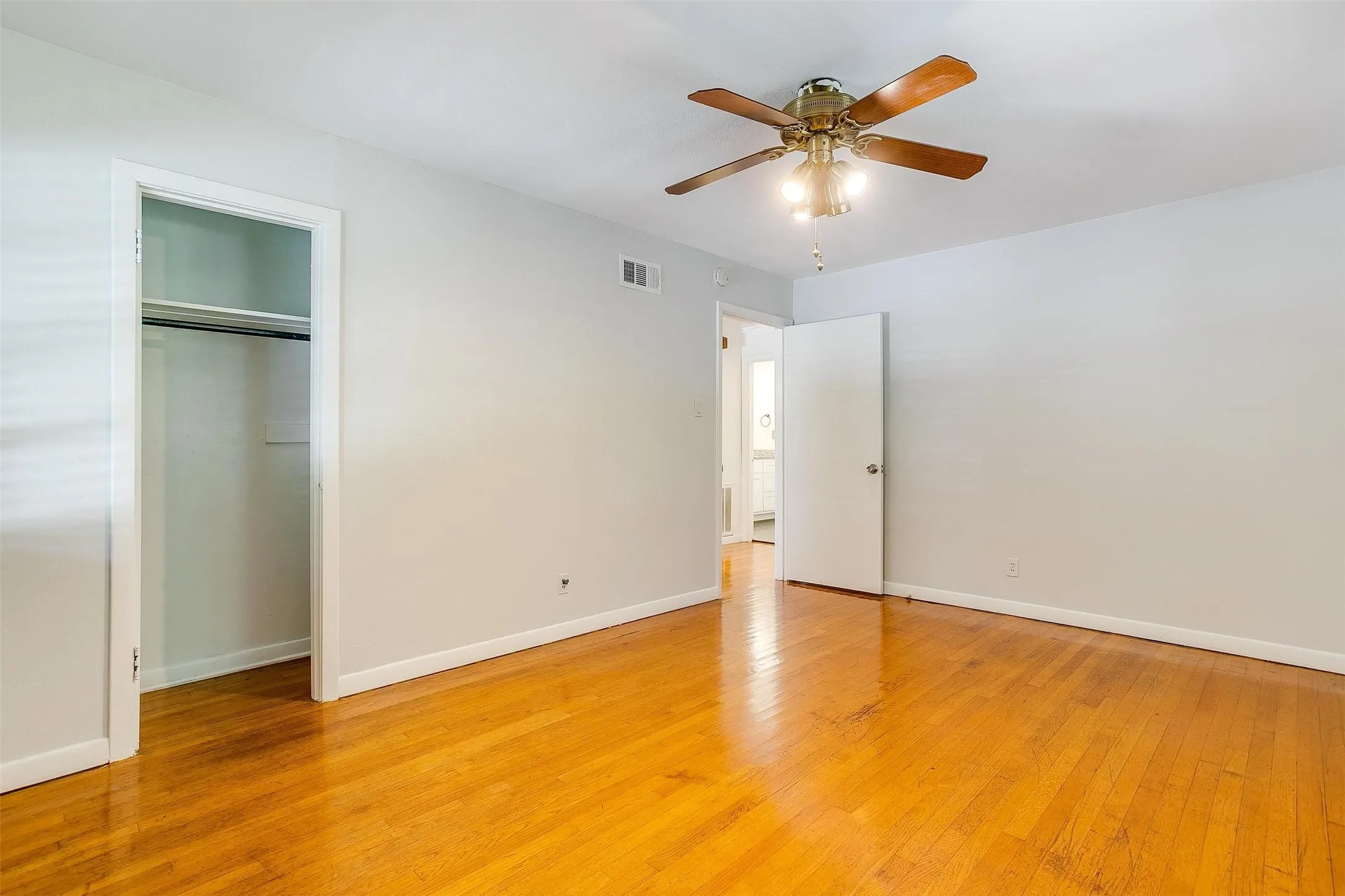 Unfurnished bedroom featuring a closet, ceiling fan, and light hardwood / wood-style flooring