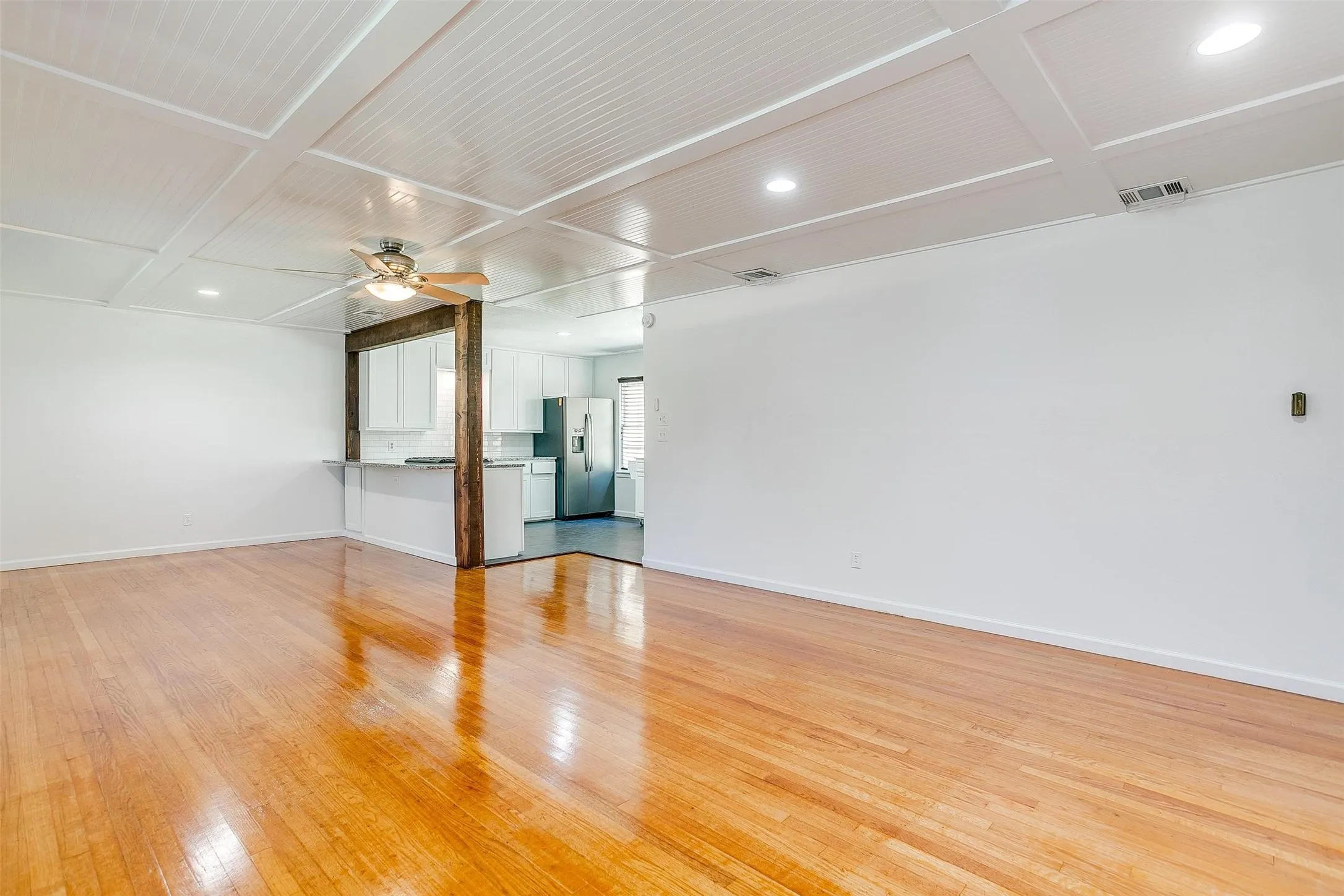 Spare room with coffered ceiling, ceiling fan, and light hardwood / wood-style flooring