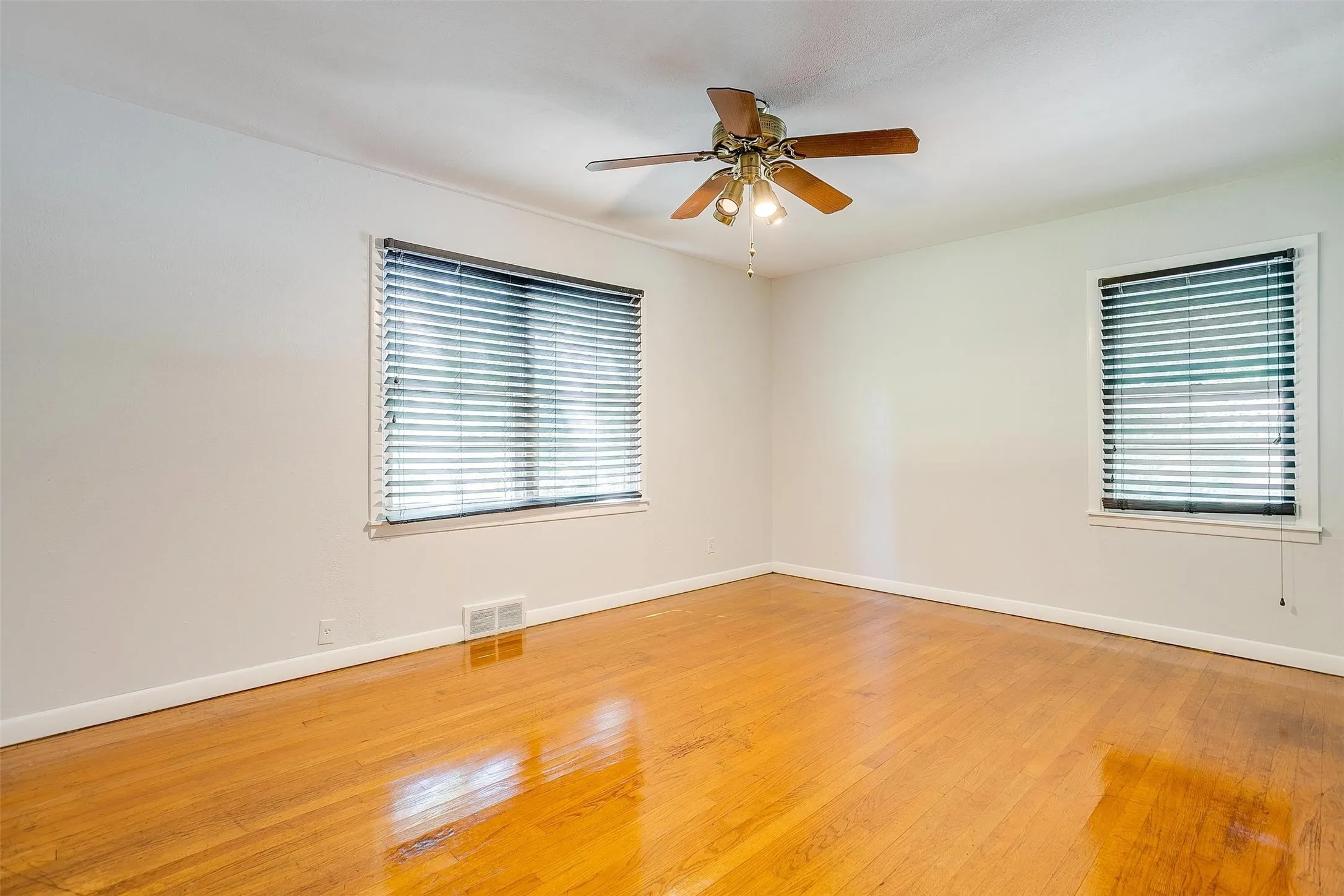 Unfurnished room with ceiling fan and light wood-type flooring