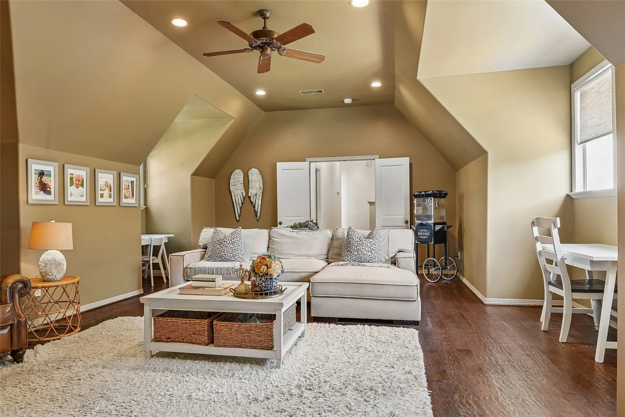 Vaulted ceilings, wood-finish flooring, recessed lighting, and a centrally mounted ceiling fan