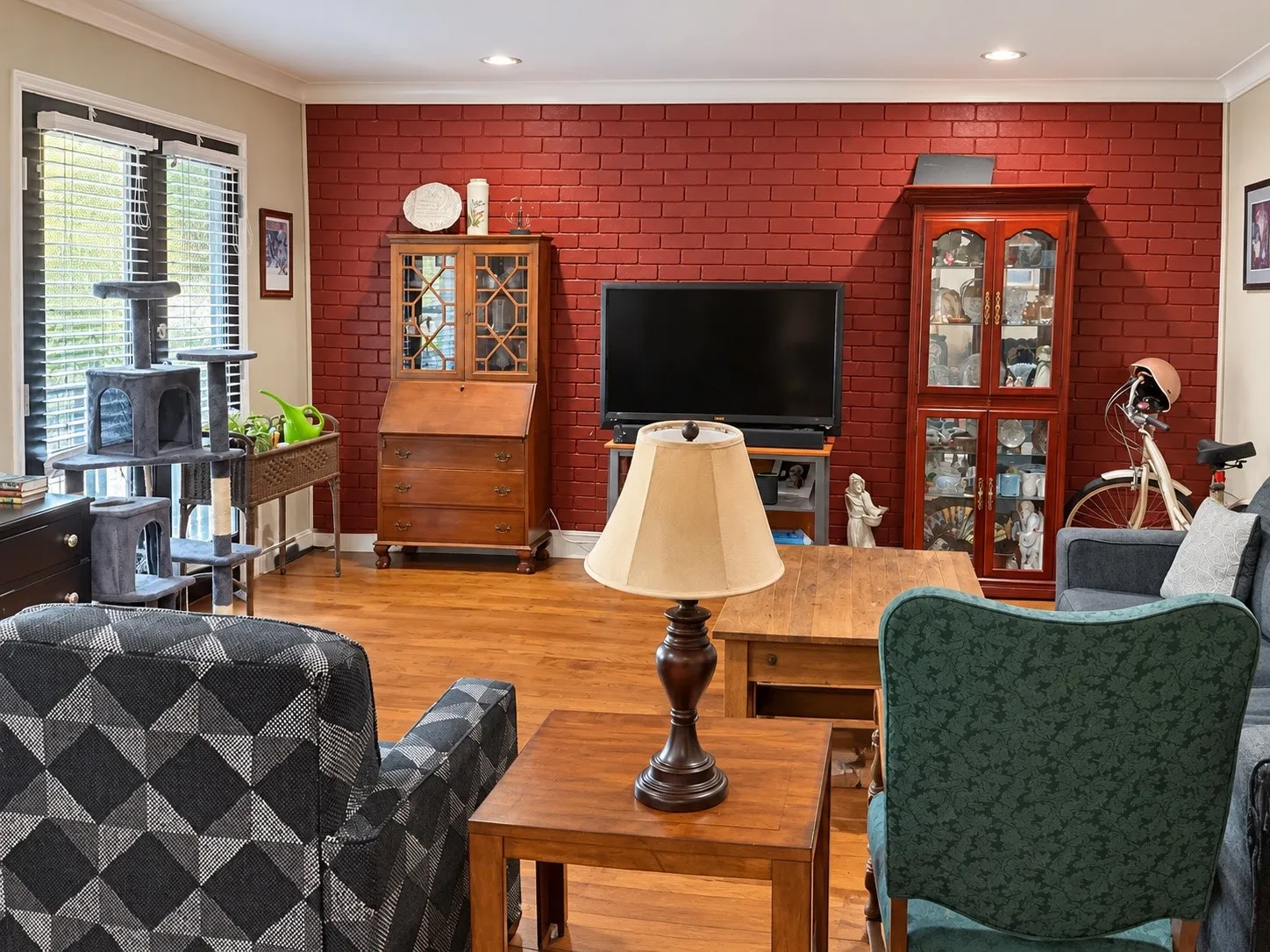 Painted brick accent wall, wood-finish flooring, recessed lighting, crown molding, and glass-paneled double doors