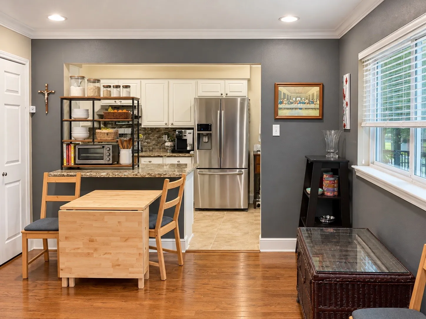 Kitchen featuring white shaker-style cabinetry, stone-finish countertops, stainless steel refrigerator, and recessed lighting, accented by wood-finish flooring