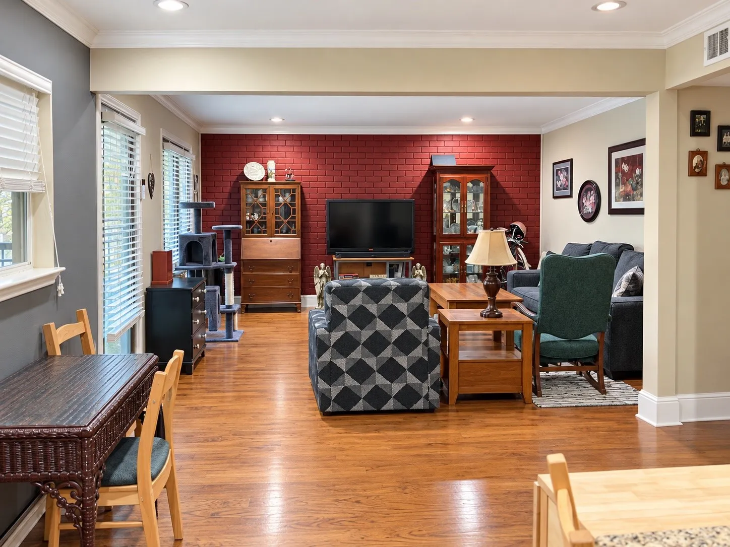 Interior featuring wood-finish flooring, a red painted brick accent wall, and recessed ceiling lighting