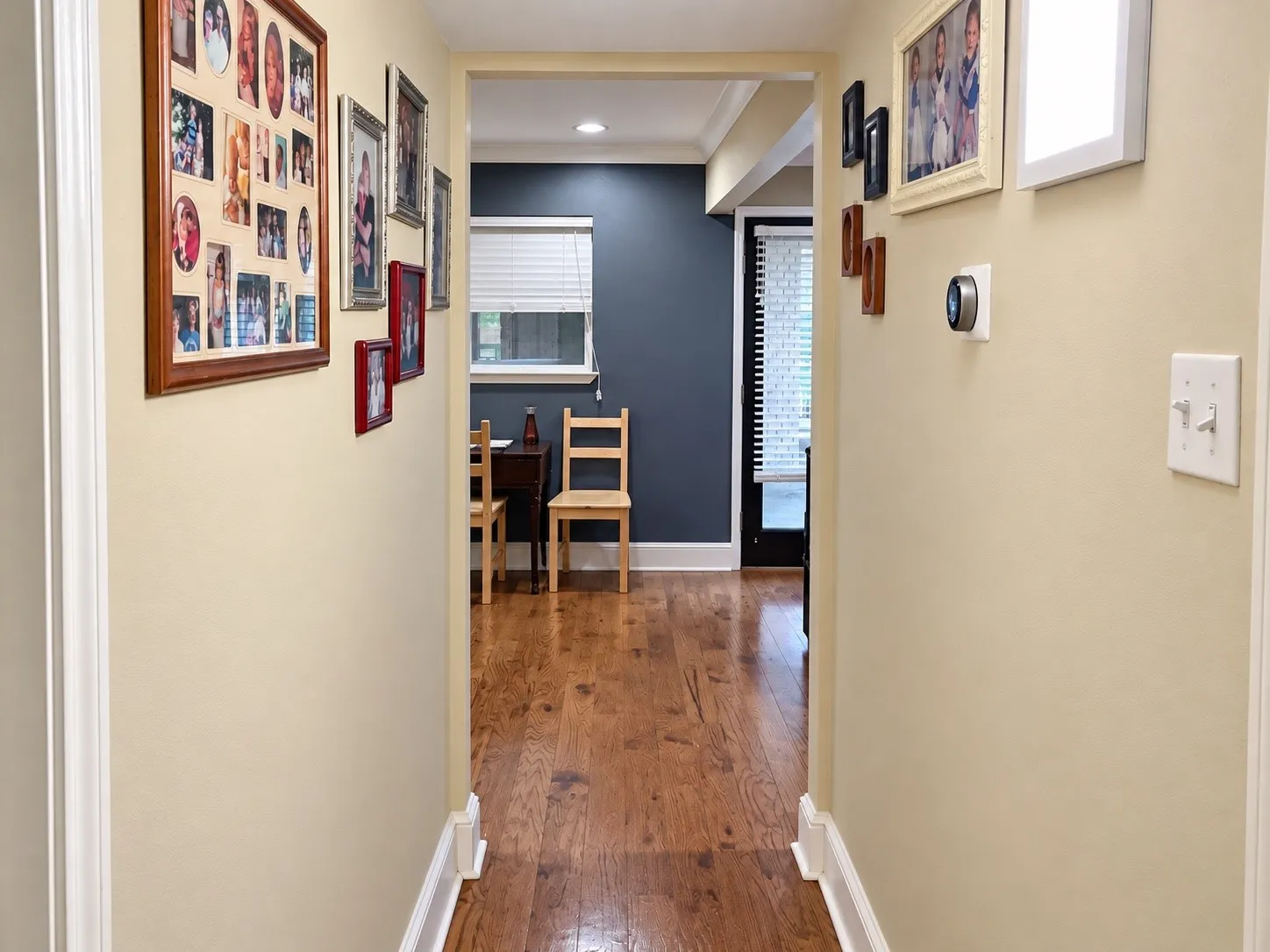 Interior hallway featuring wood-finish flooring, recessed ceiling lighting, and a smart thermostat