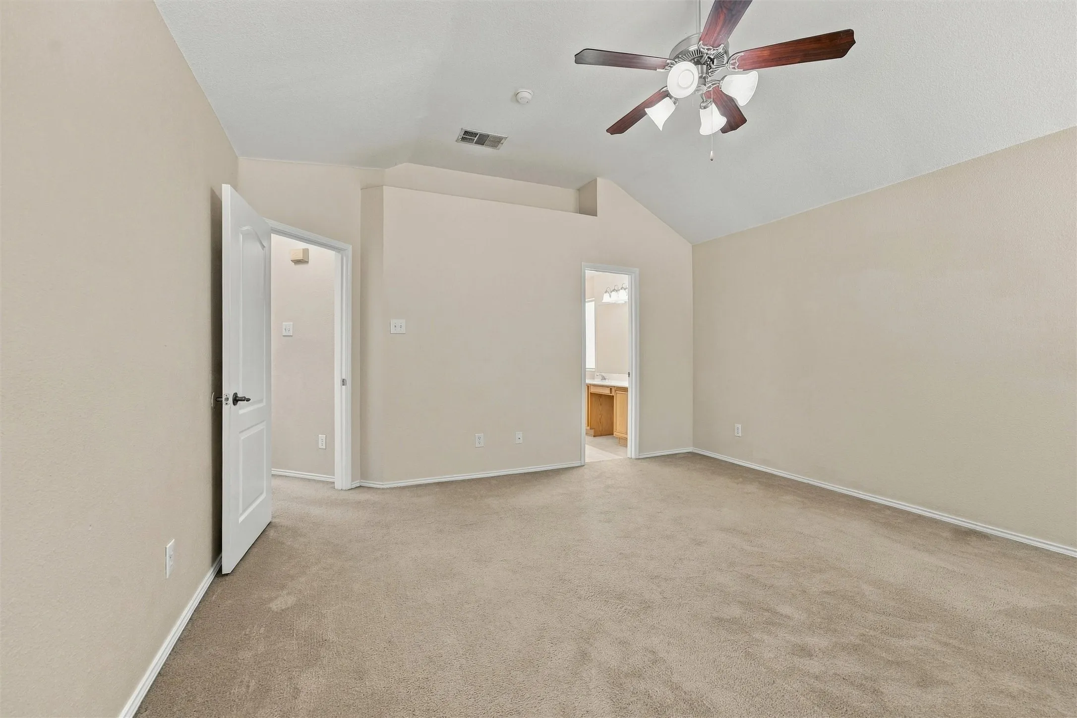 Room featuring a vaulted ceiling, neutral wall coloring, carpeted flooring, and a ceiling fan with integrated lighting