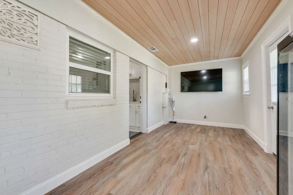 Interior space featuring white-painted brick walls, wood-finish flooring, a wood-plank ceiling, and recessed lighting