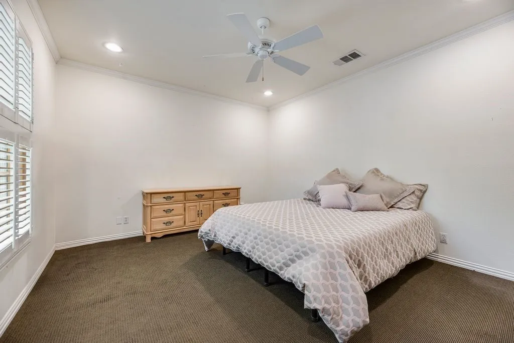 Spacious interior featuring high ceilings, crown molding, recessed lighting, a white ceiling fan, and plantation shutters