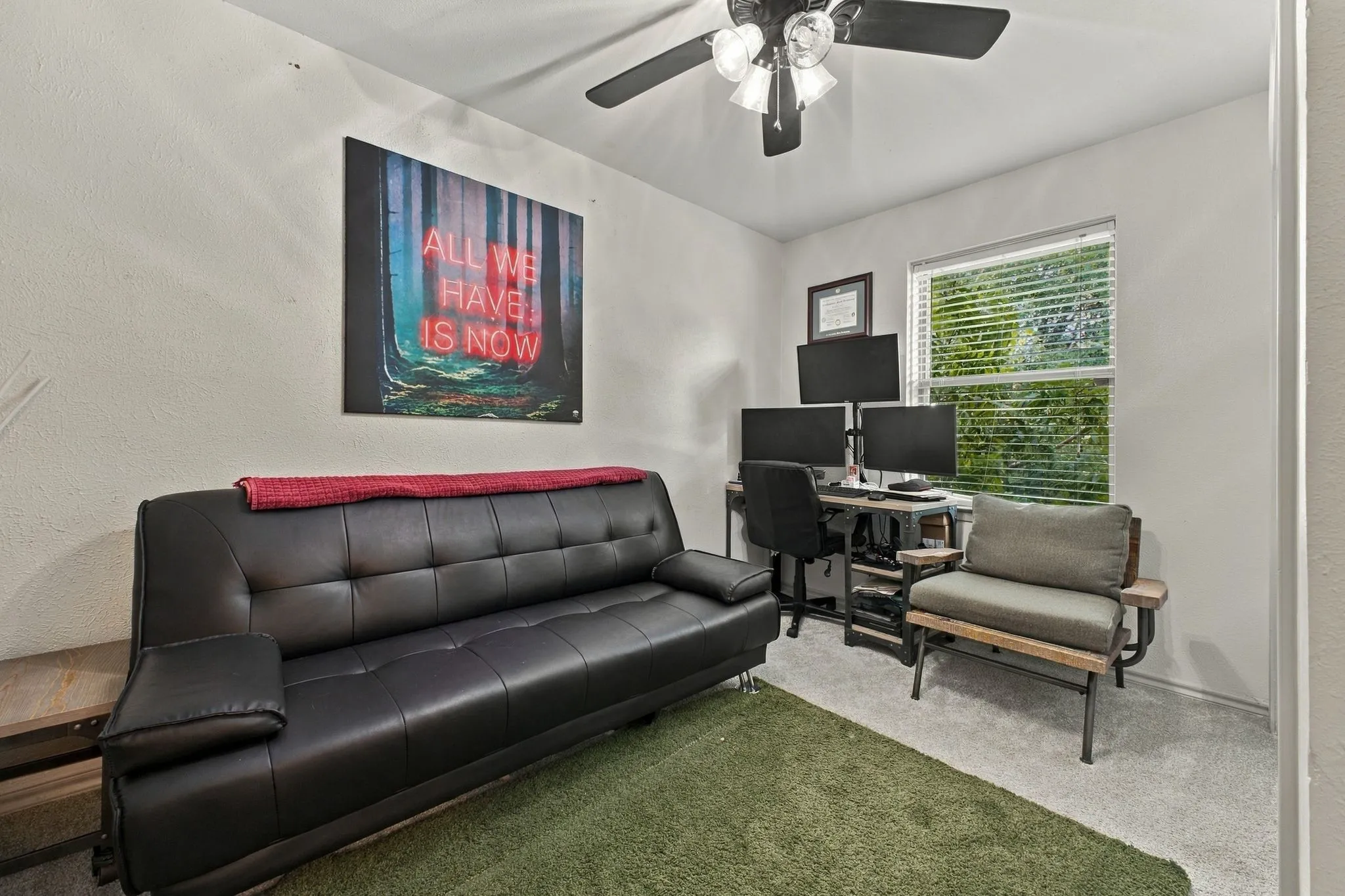 Room featuring neutral-toned carpeting, a multi-blade ceiling fan with integrated lighting, and a window with horizontal blinds