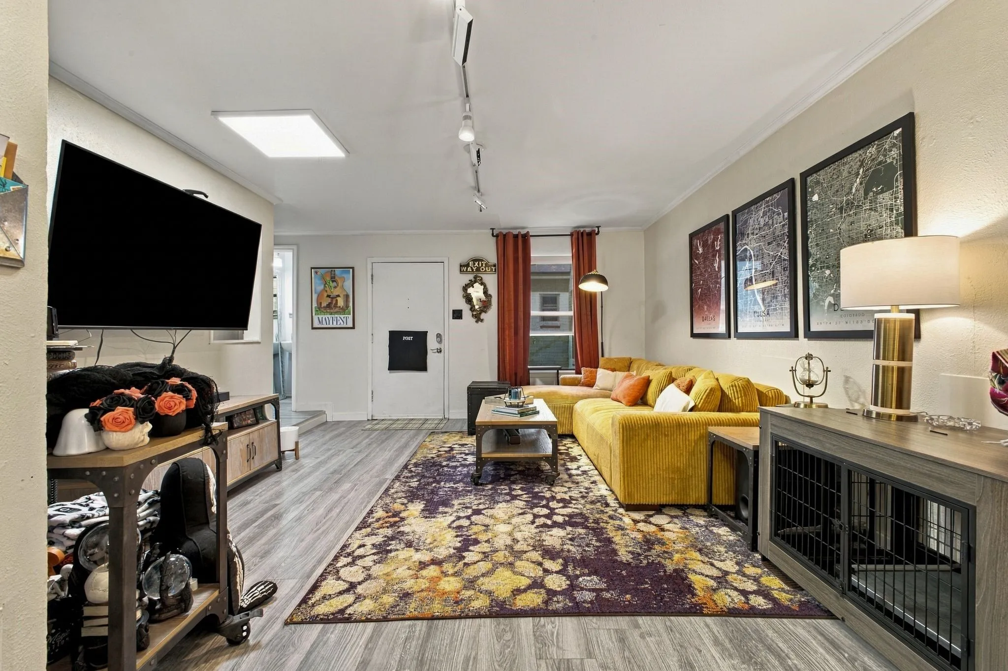 Living area featuring wood-finish flooring, adjustable track lighting, and a square recessed ceiling light