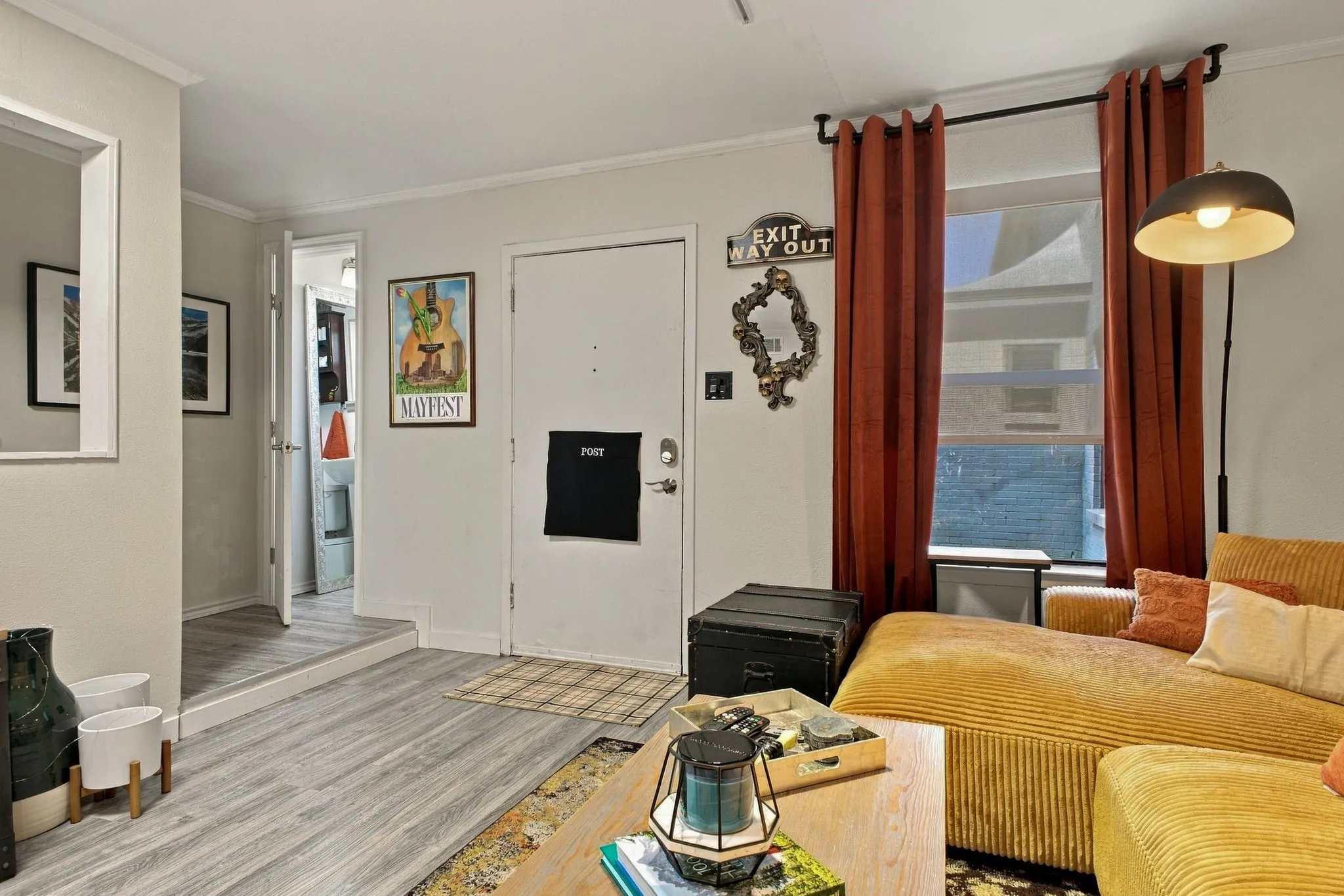 Living area featuring wood-finish flooring, a raised platform elevation, and a window with a curtain rod assembly